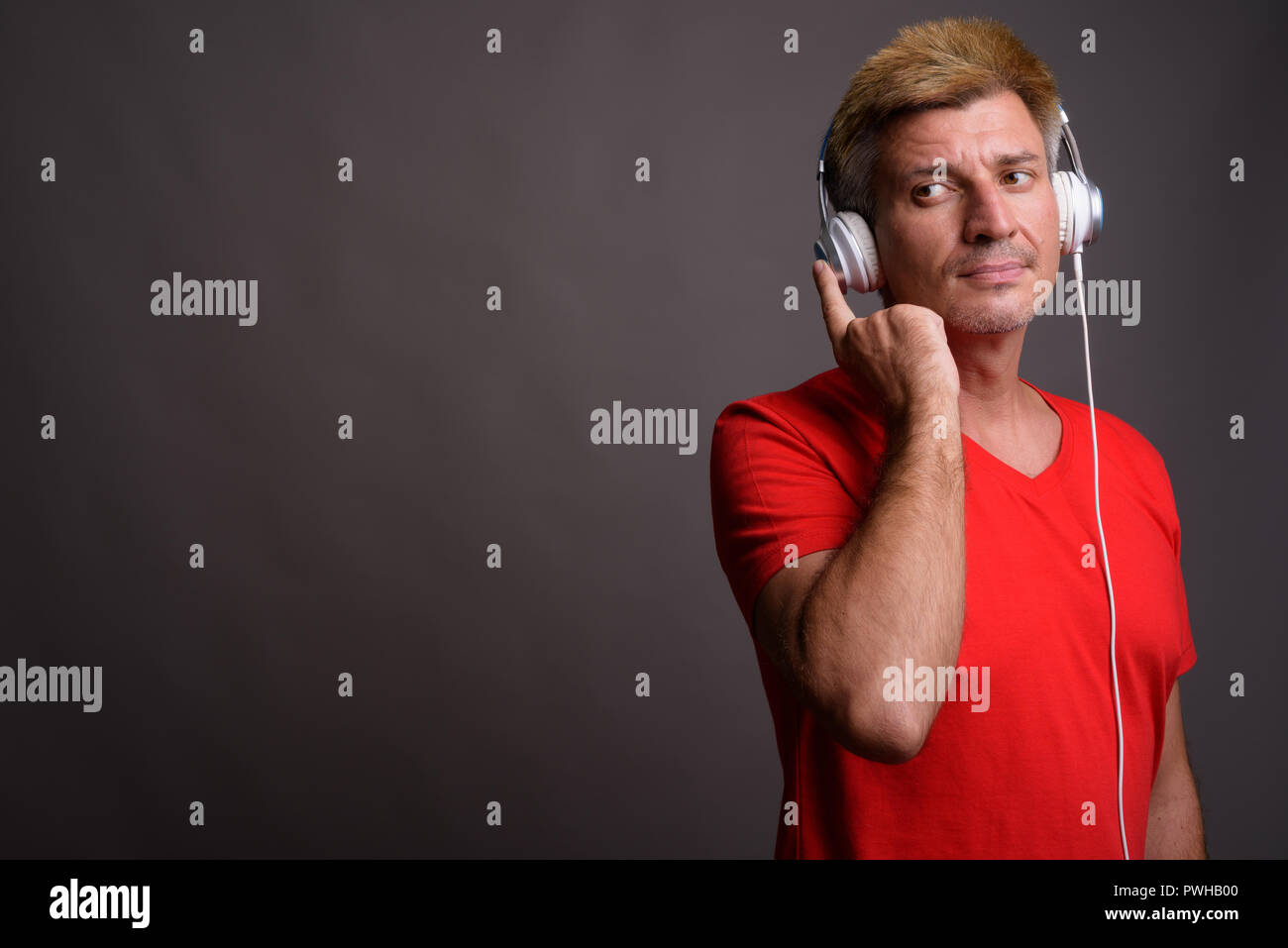 Mann mit blonden Haaren Musik gegen grauer Hintergrund Stockfoto