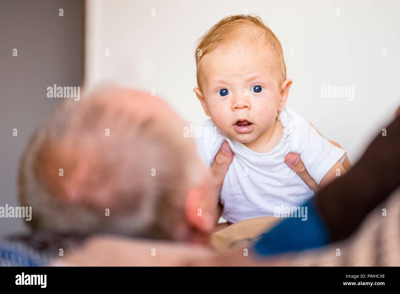 Vater spielen mit Kleinkind baby boy Suchen in die Kamera Stockfoto
