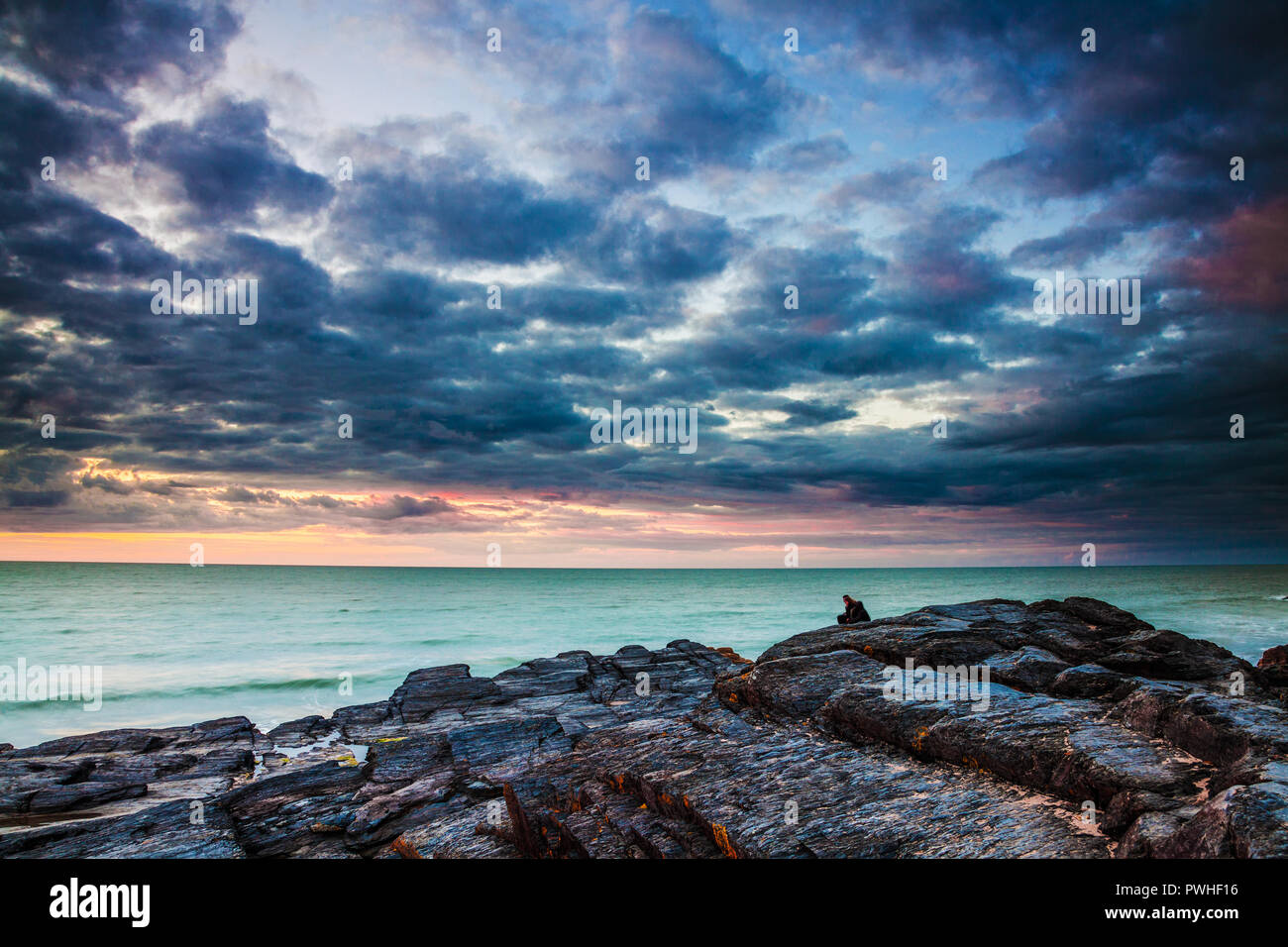 Sonnenuntergang über dem Strand von Tresaith, Ceredigion, Wales, in Richtung Aberporth. Stockfoto