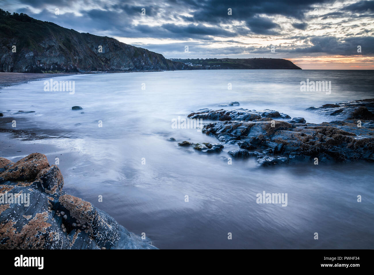 Sonnenuntergang über dem Strand von Tresaith, Ceredigion, Wales, in Richtung Aberporth. Stockfoto