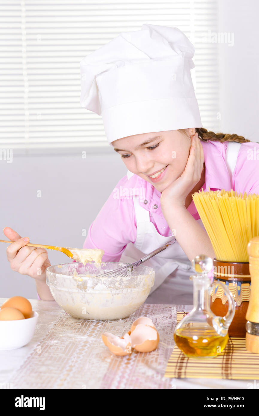 Süße Mädchen in Kochmütze Kochen in der Küche Stockfoto