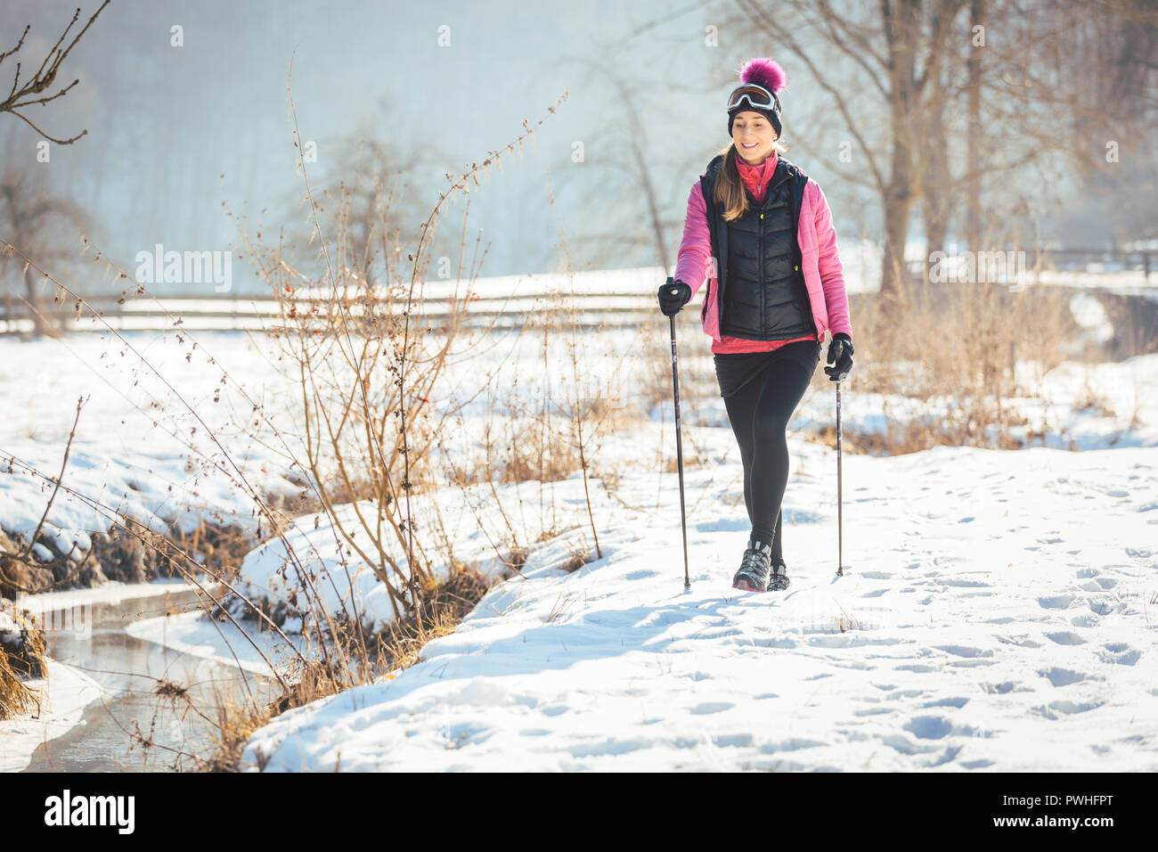 Passende Frau Nordic Walking im Winter Landschaft Stockfoto