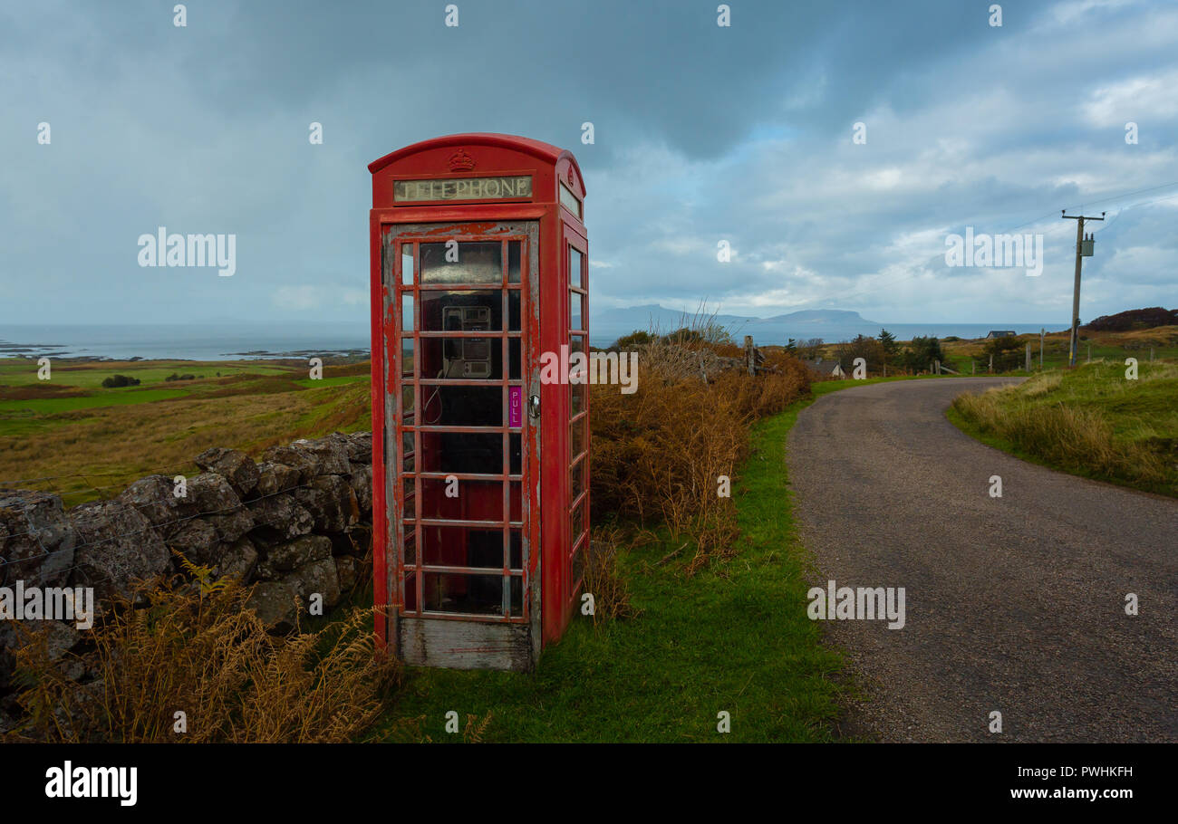 Altmodische rote Telefonzelle, verlassenen und Verstorbenen in einem ländlichen Dorf in den Highlands von Schottland mit Blick auf den Hebriden Insel Eigg. Stockfoto