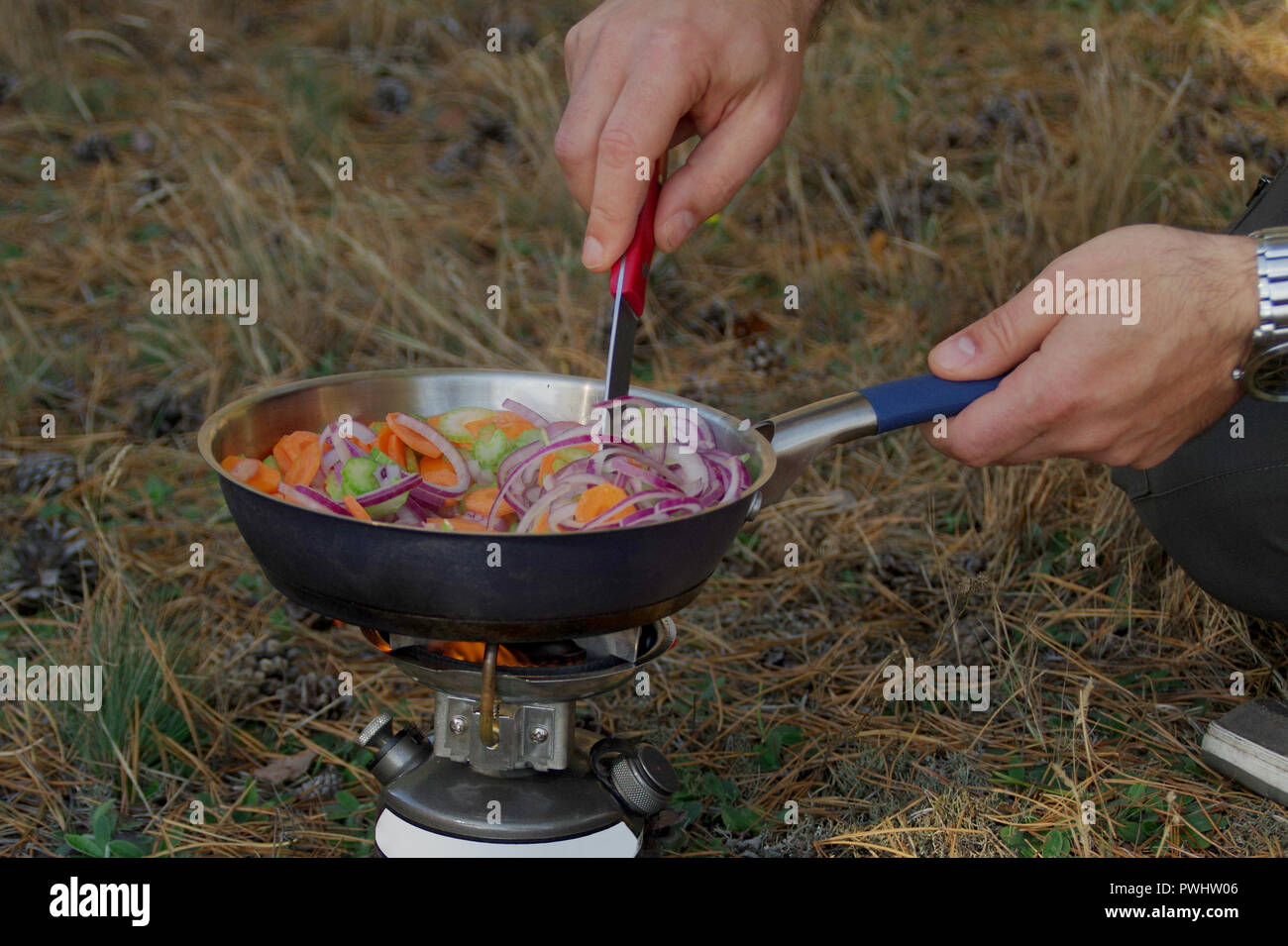 Vorbereitung eine frische Mahlzeit auf einem touristischen Herd im Freien. Stockfoto