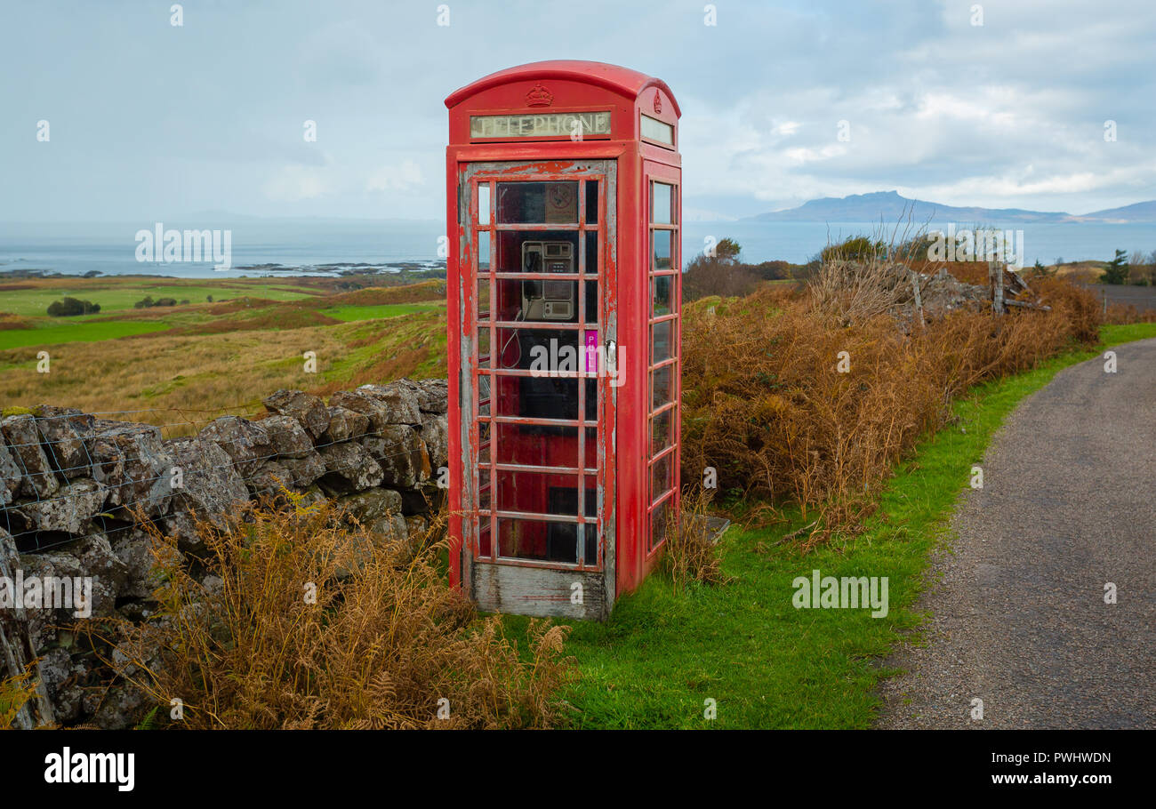 Altmodische rote Telefonzelle, verlassenen und Verstorbenen in einem ländlichen Dorf in den Highlands von Schottland mit Blick auf den Hebriden Insel Eigg. Stockfoto