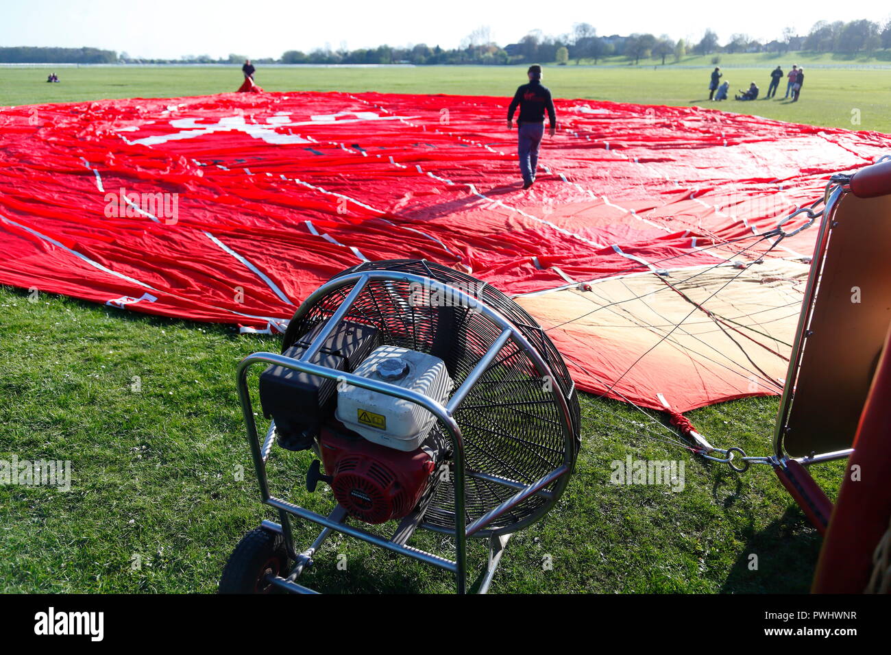 Ein Lüfter wird eingesetzt zur Unterstützung der Einrichtung einer Jungfrau heissluftballon auf der Rennbahn von York, North Yorkshire. Stockfoto