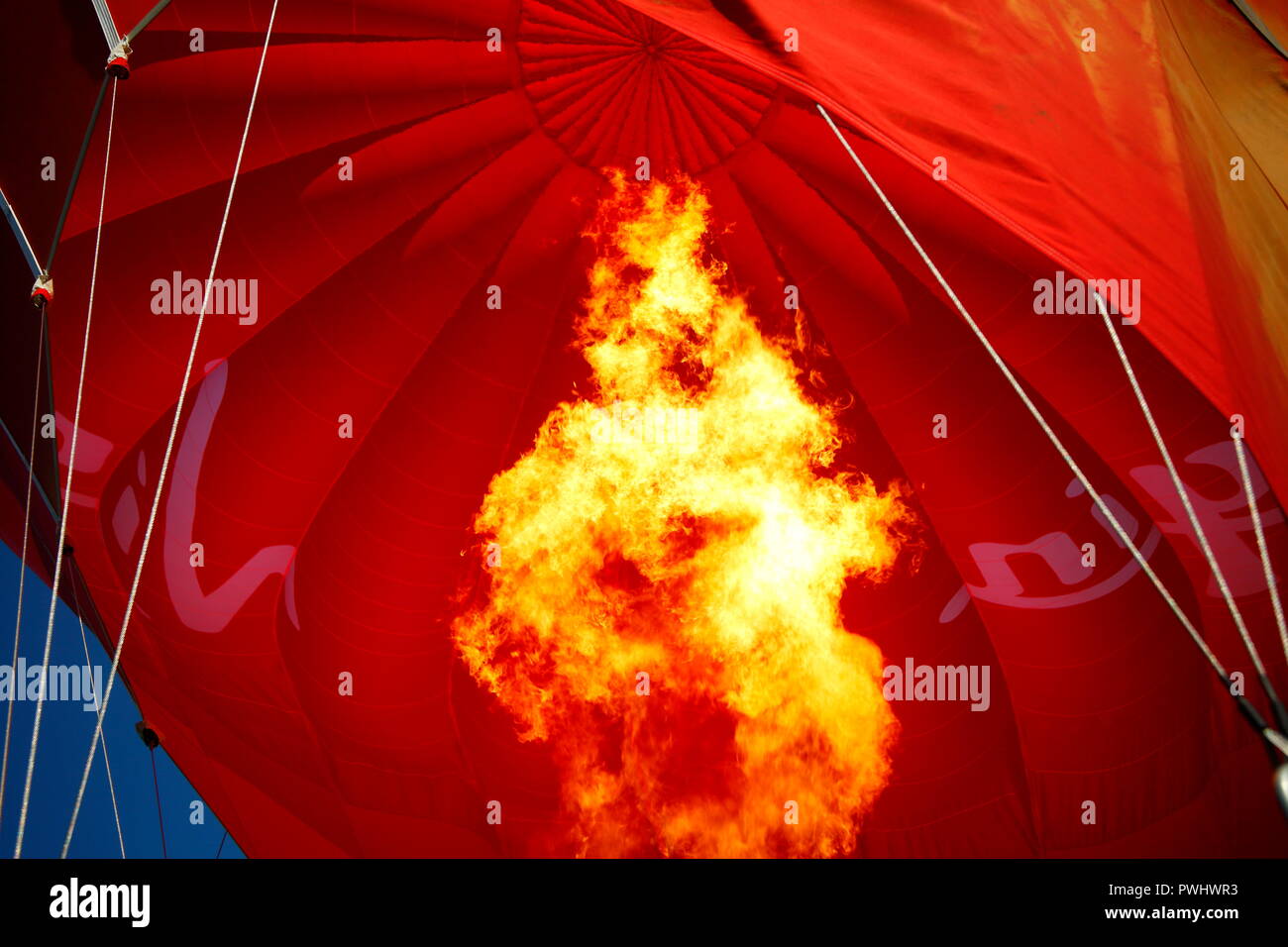 Flammen aufpumpen eine Jungfrau heissluftballon auf der Rennbahn von York, North Yorkshire Stockfoto