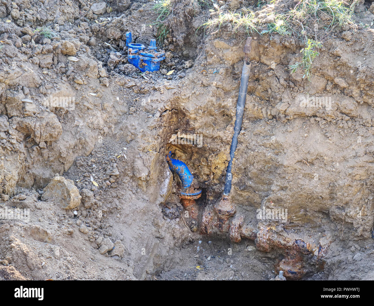 Graben für die Verlegung einer Pipeline. Bau von Trinkwasserleitungen mit Tor in flachen Graben. Stockfoto