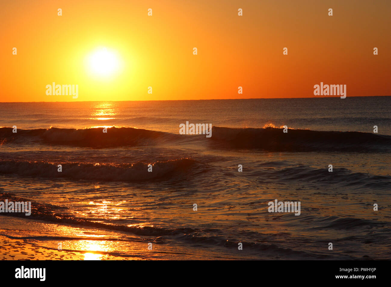 Sonnenaufgang über dem Atlantik mit glitzernden Wellen. Stockfoto