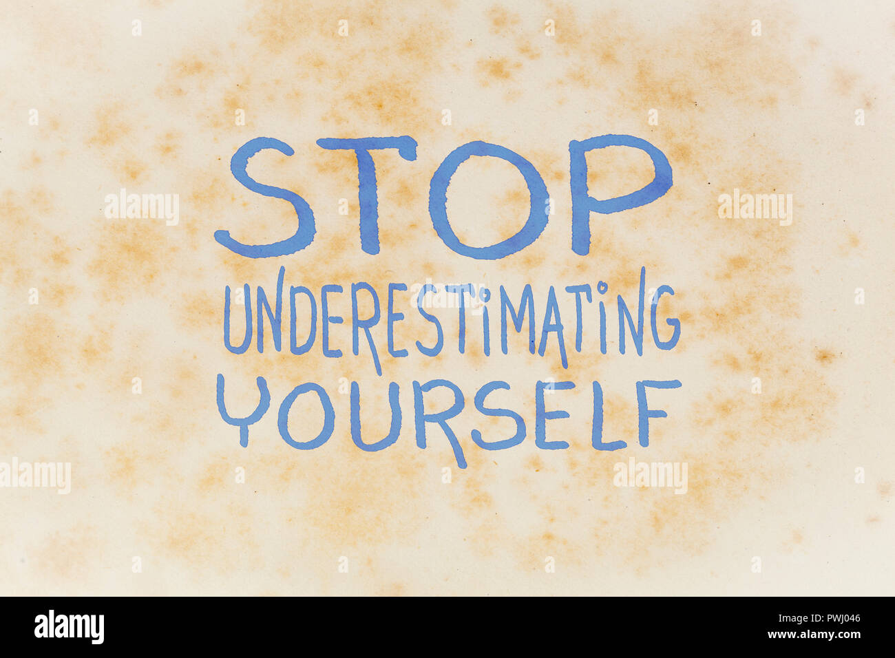 Stop unterschätzen Selbst - inspirational Handschrift auf einem alten vergilbten Papier Stockfoto