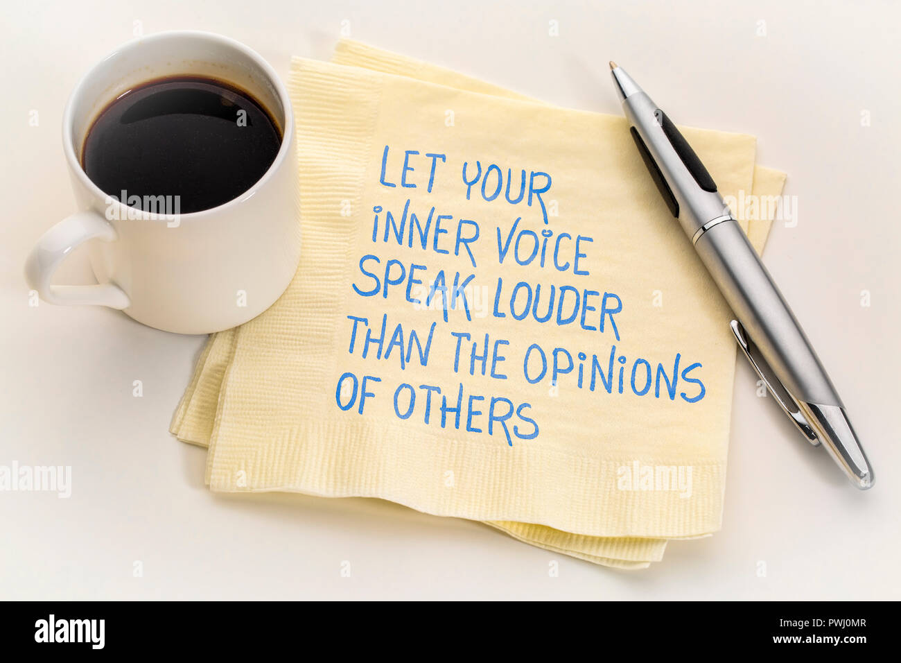 Lassen Sie Ihre innere Stimme sprechen lauter als die Meinung der Anderen - inspirtional Handschrift auf eine Serviette mit einer Tasse Kaffee Stockfoto