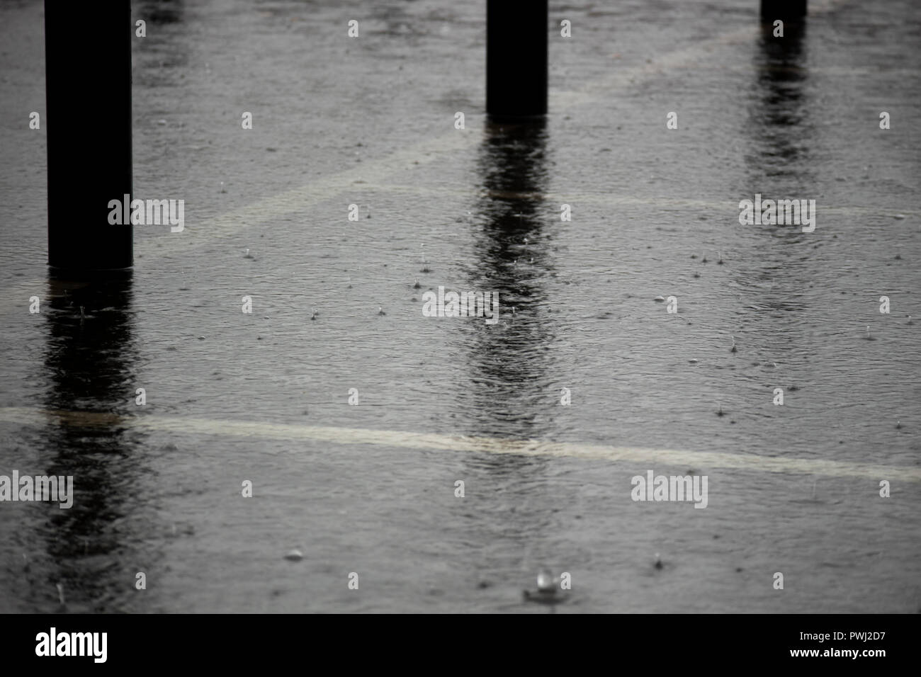 Heavy Rain mit lokalisierten Überschwemmungen in Supermarkt Parkplatz Stockfoto