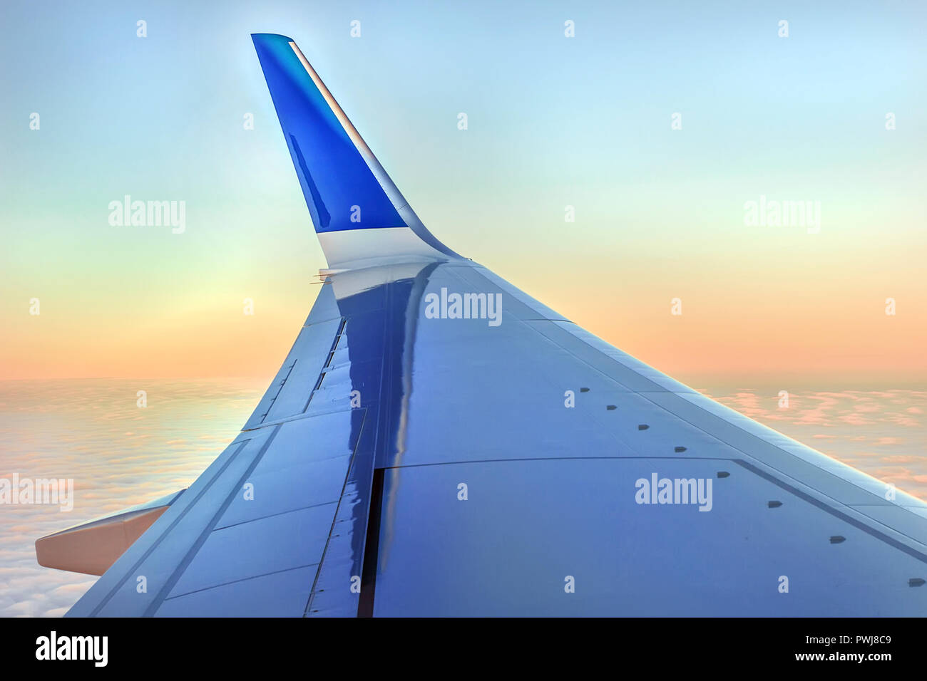 Flügel der Luftfahrzeuge, die in der Morgendämmerung rosa Himmel mit Licht weichen Wolken Stockfoto