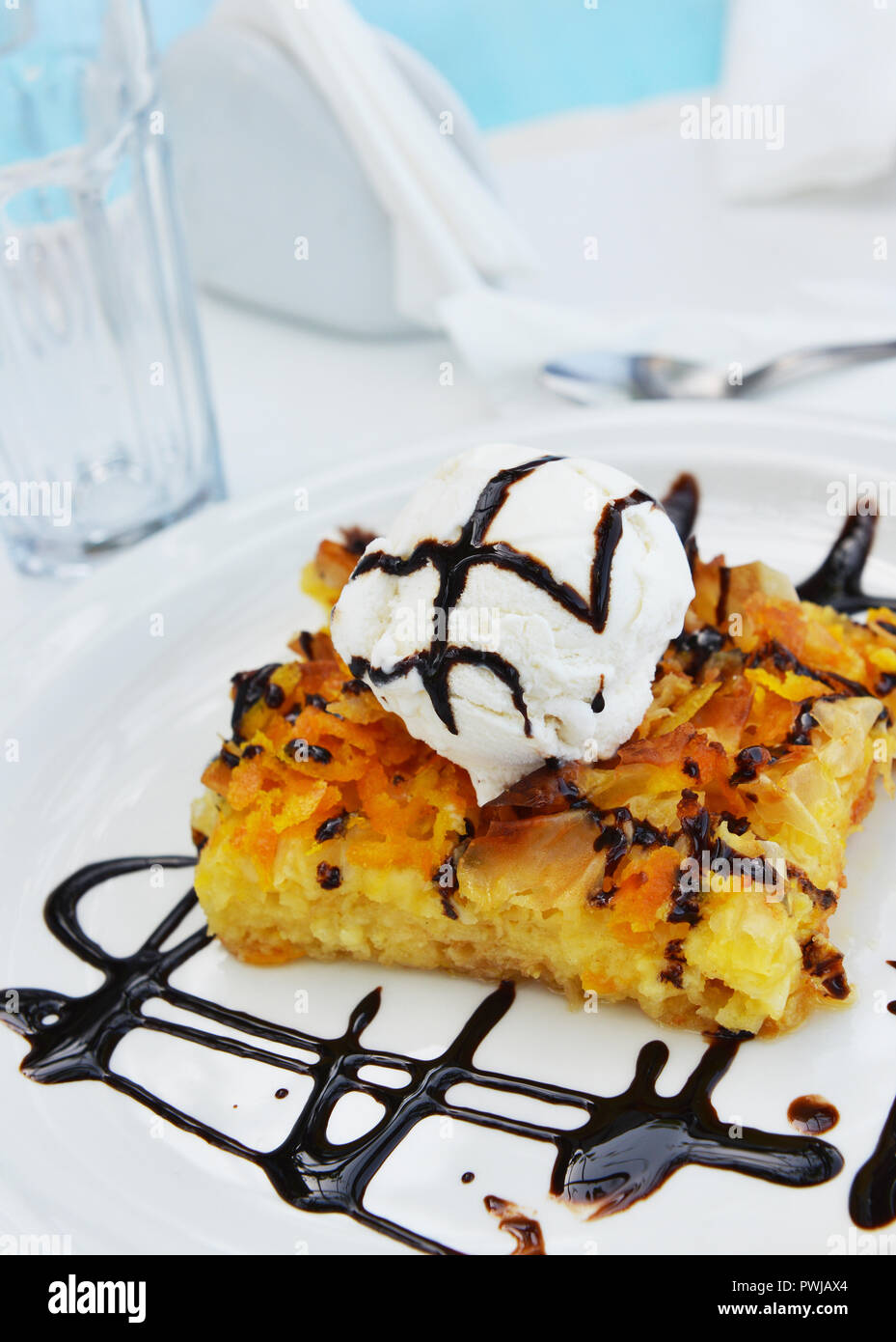 Orange Kuchen mit Vanilleeis und Schokoladensauce Stockfoto