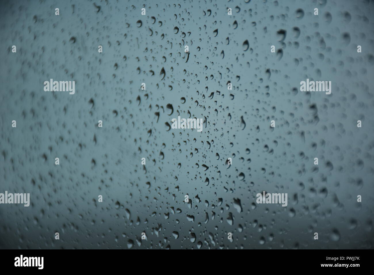 Regen fällt auf Glas Stockfoto