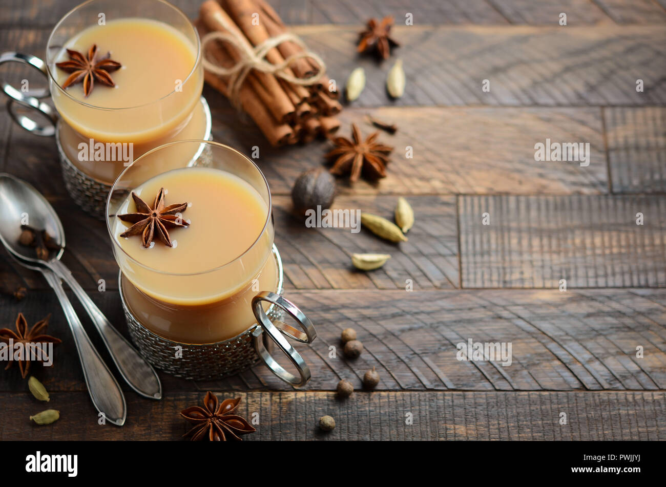 Indische Masala Chai Tee. Gewürzten Tee mit Milch in einem Vintage cups auf der rustikalen Holztisch. Stockfoto