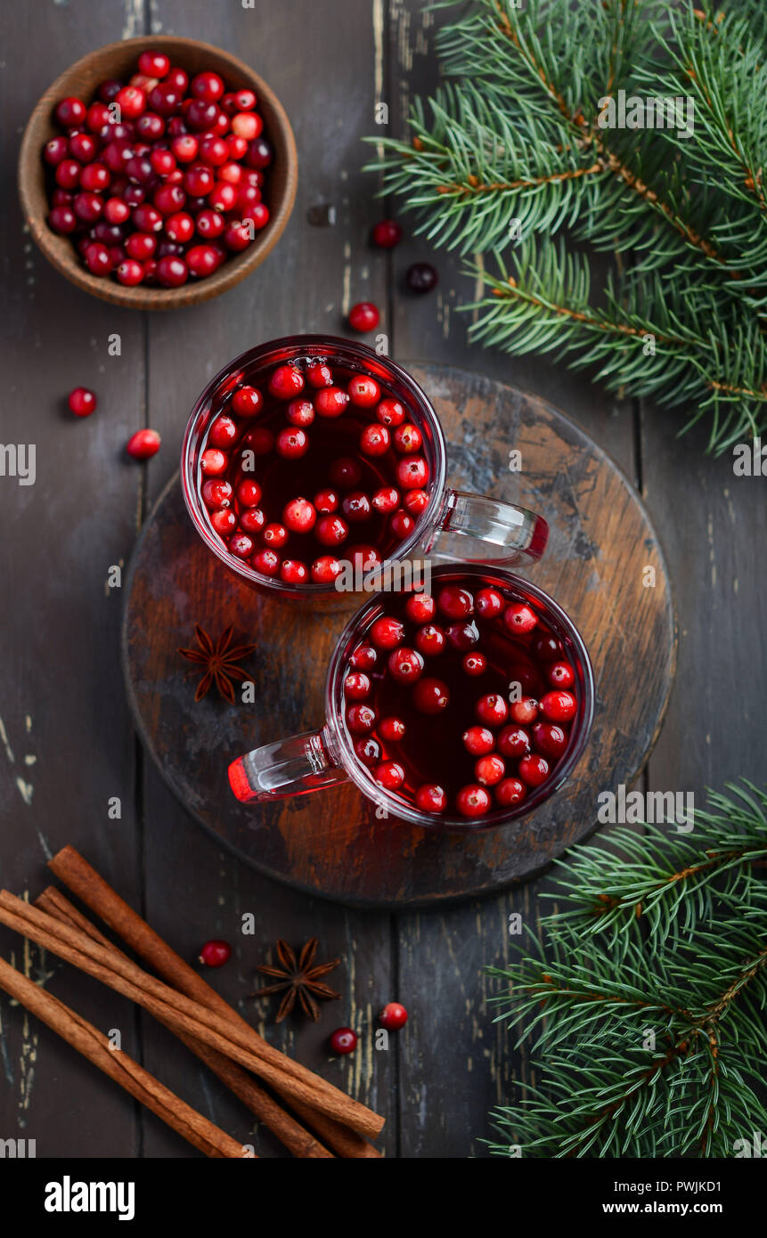 Cranberry Drink auf Holz- Hintergrund dekoriert mit Tannenzweigen, Gewürzen und frischen Beeren Stockfoto
