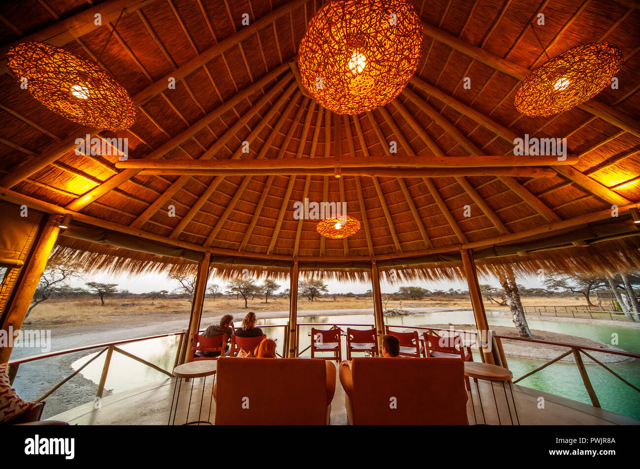 Touristen beobachten das Wasserloch auf Onguma Bush Camp in der Nähe von lundquist Gate des Etosha Nationalpark, Namibia Stockfoto