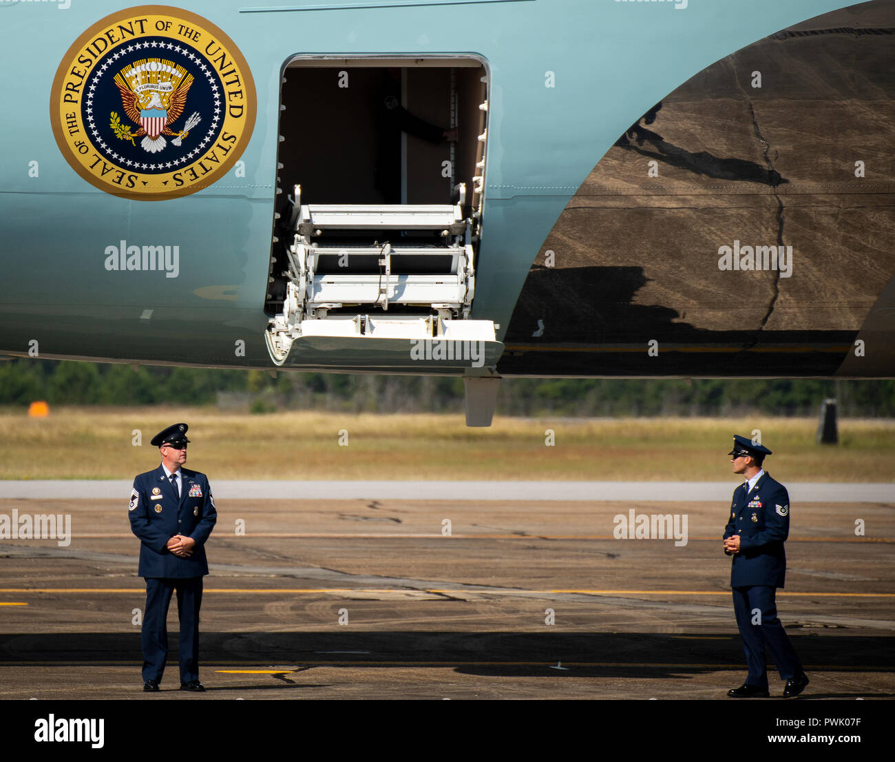 Ein Chief Master Sergeant und eine tech Sergeant stehen außerhalb der Air Force One zu den Stufen steigen an der Eglin Air Force Base, Fla., Okt. 15. Der Flieger stand am unteren Ende der Treppe und Grüßte als Präsident Donald J. Trumpf das Flugzeug verlassen. Trump gestoppt bei Eglin auf dem Weg nach Panama City die Verwüstung durch den Hurrikan Michael zu sehen. (U.S. Air Force Foto/Samuel King Jr.) Stockfoto