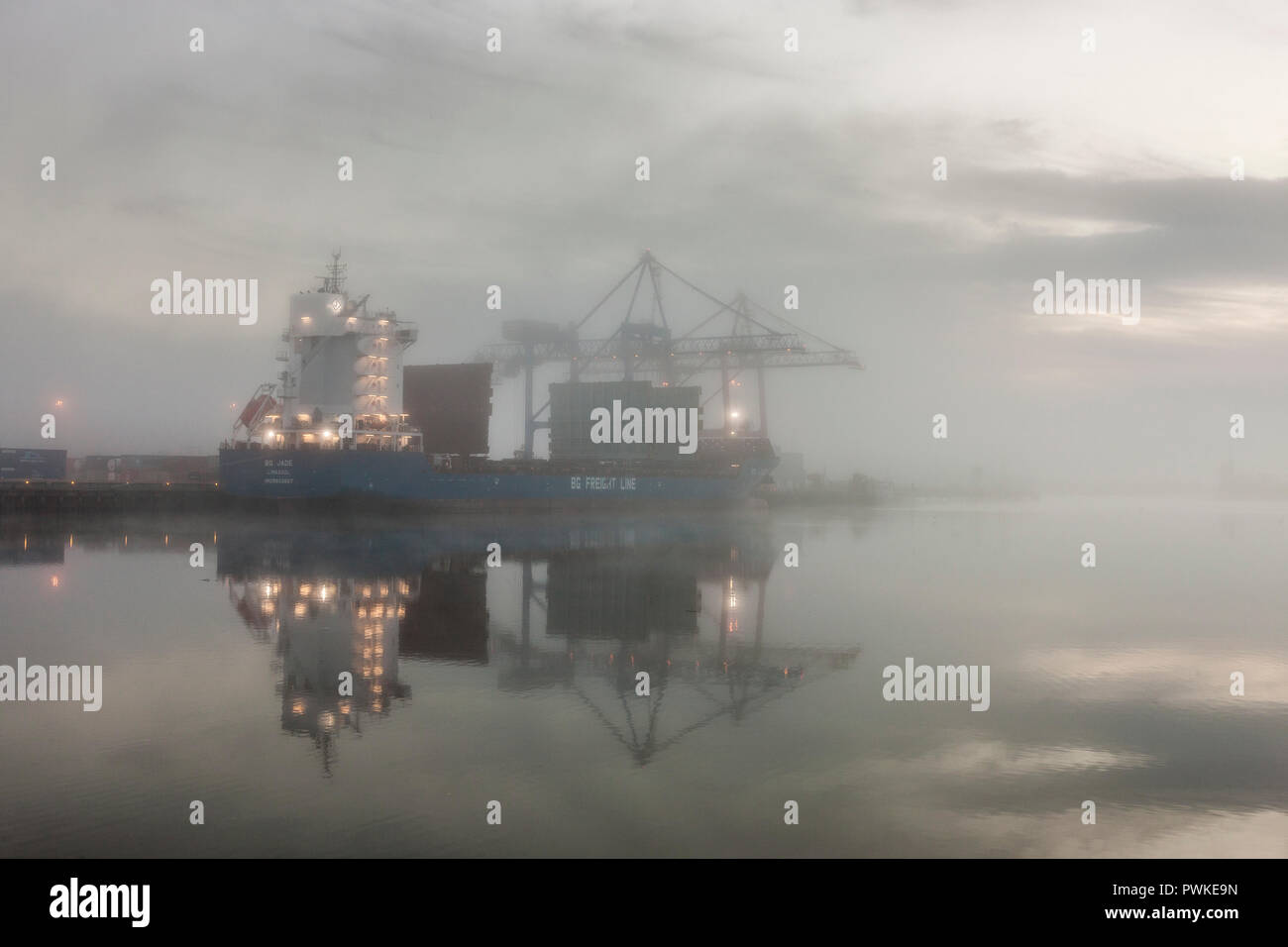 Tivoli, Cork, Irland. 17. Oktober, 2018. Am frühen Morgen Nebel hinunter auf den Hafen als Frachtschiff BG Jade ist mit Containern im Tivoli Docks, Cork, Irland, geladen. Quelle: David Creedon/Alamy leben Nachrichten Stockfoto