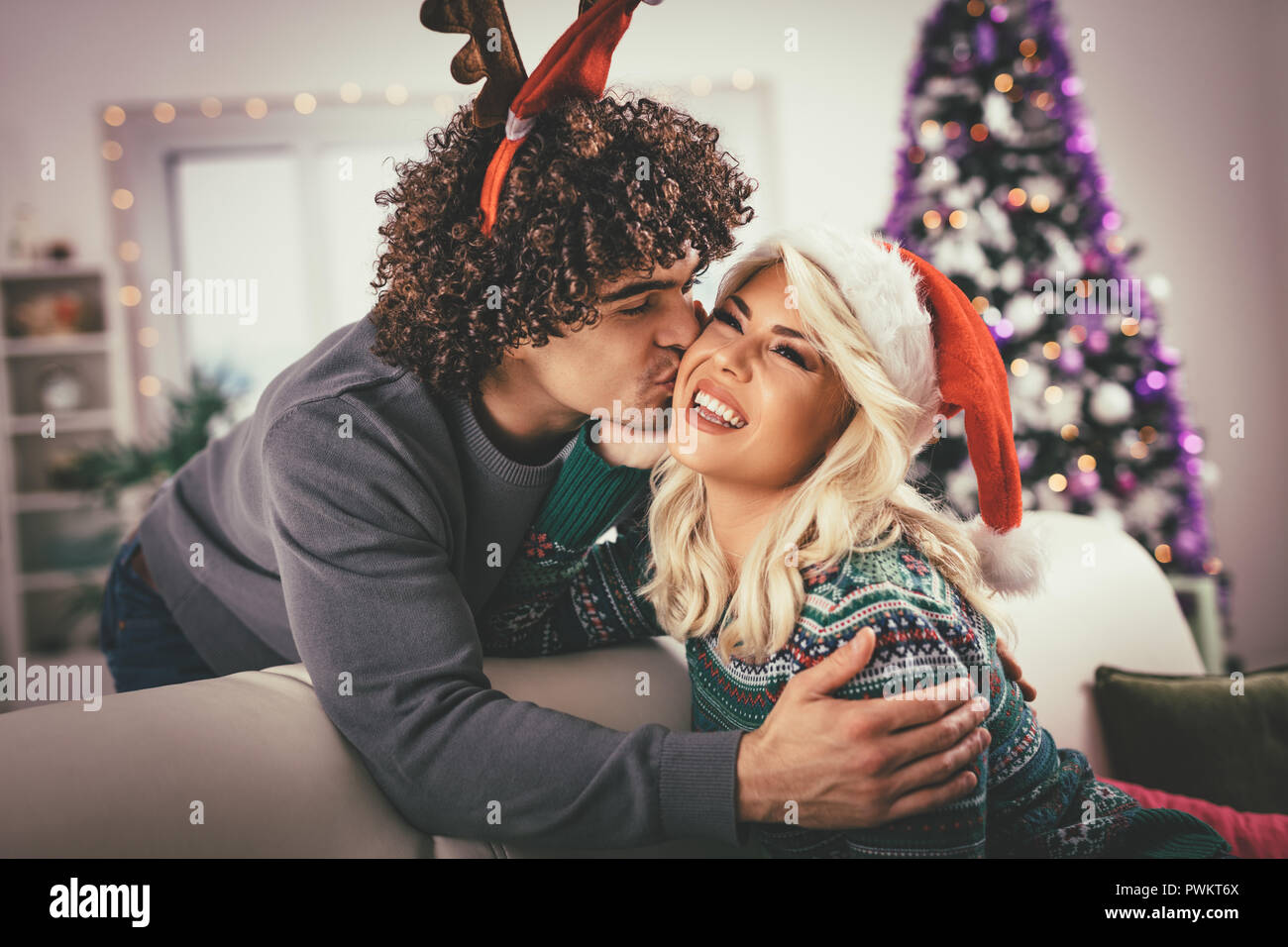 Paar in der gemütlichen warmen Pullover auf ein Weihnachten - Neujahr, Lächeln, Küssen, Spaß mit einander. Stockfoto