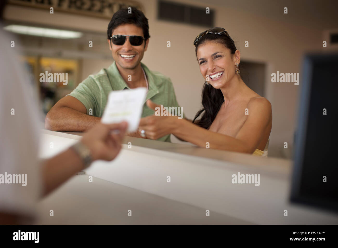 Glückliches junges paar Check-in am Flughafen Check-in Schalter. Stockfoto