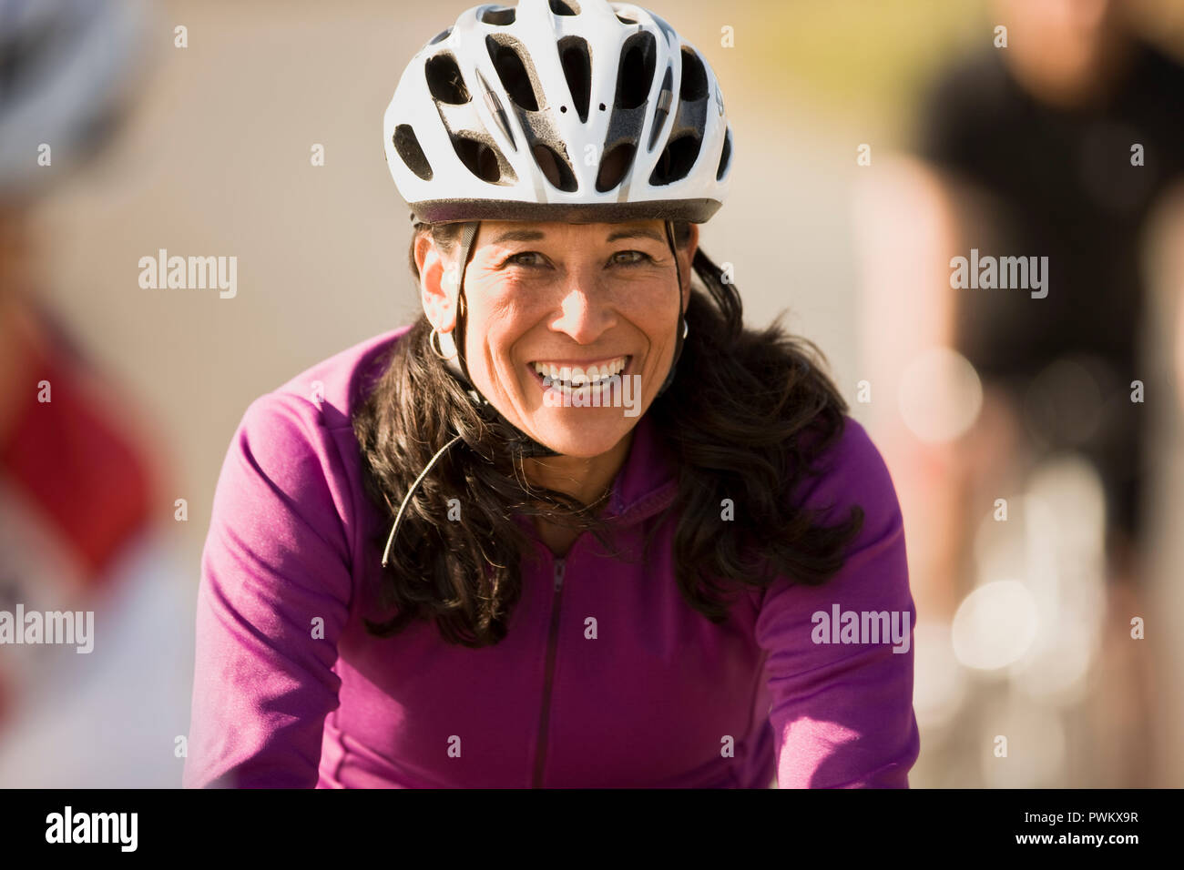 Reife Frau trägt einen Fahrradhelm und lächelnd Stockfoto