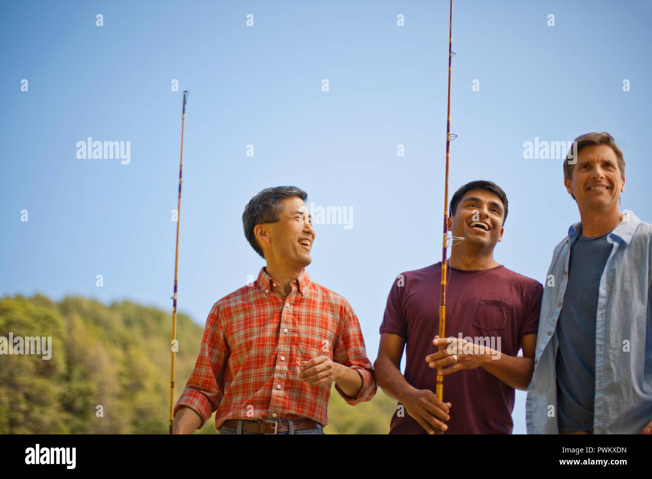 Drei Freunde sprechen und lachen während einer Angeln Ausflug. Stockfoto