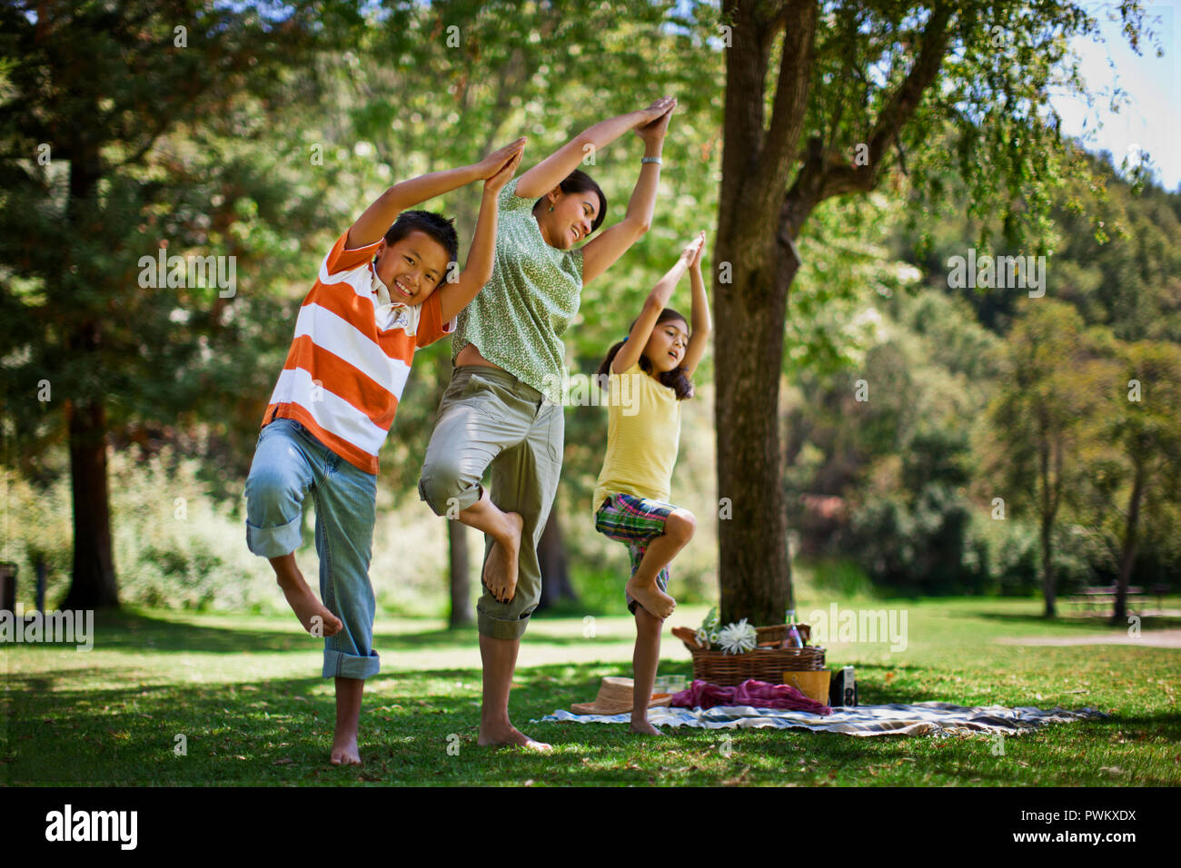 Mutter Yoga Posen mit ihren zwei Kindern. Stockfoto