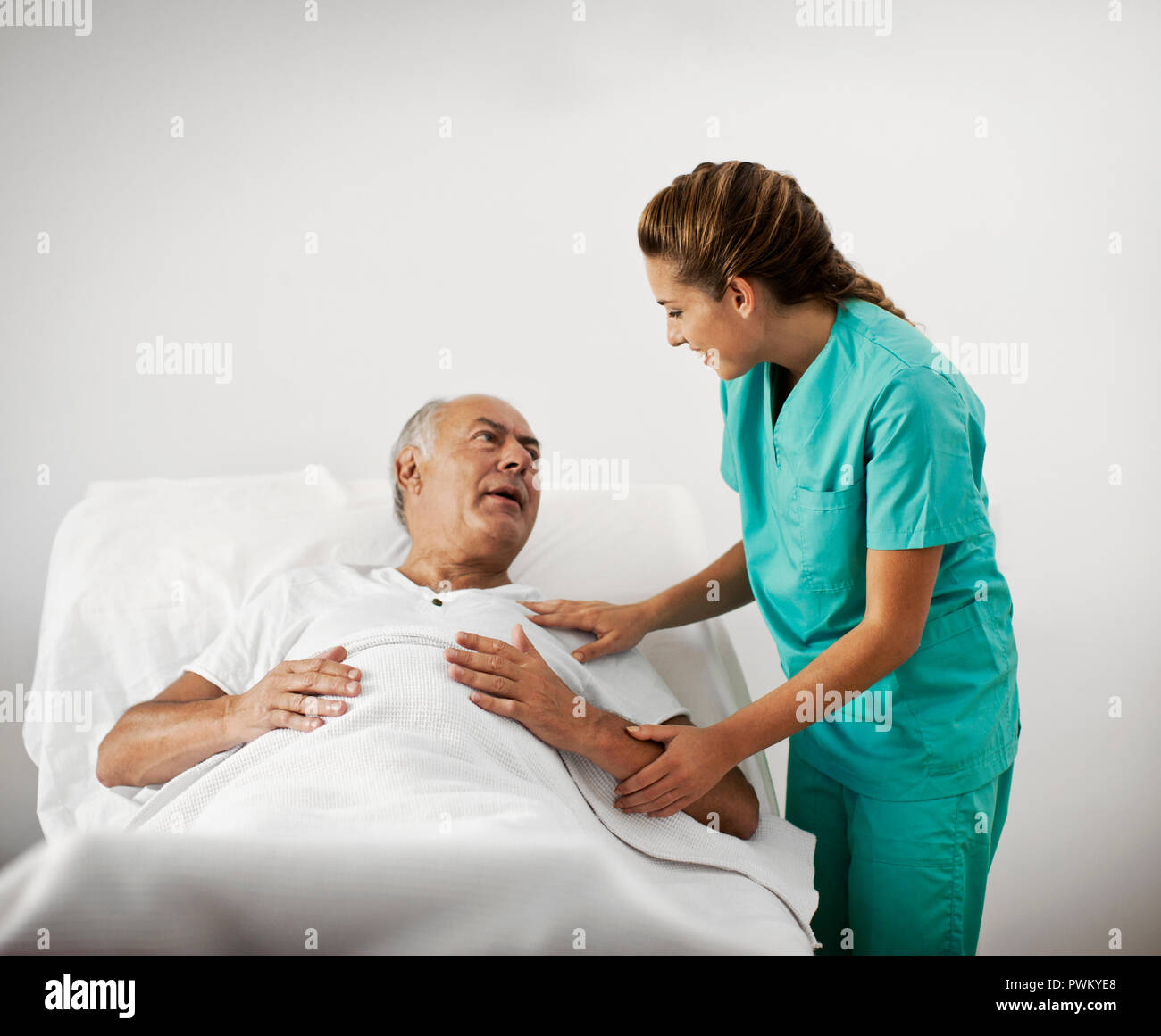 Mann im Krankenhaus erhält Besuch von seinem Krankenschwester. Stockfoto