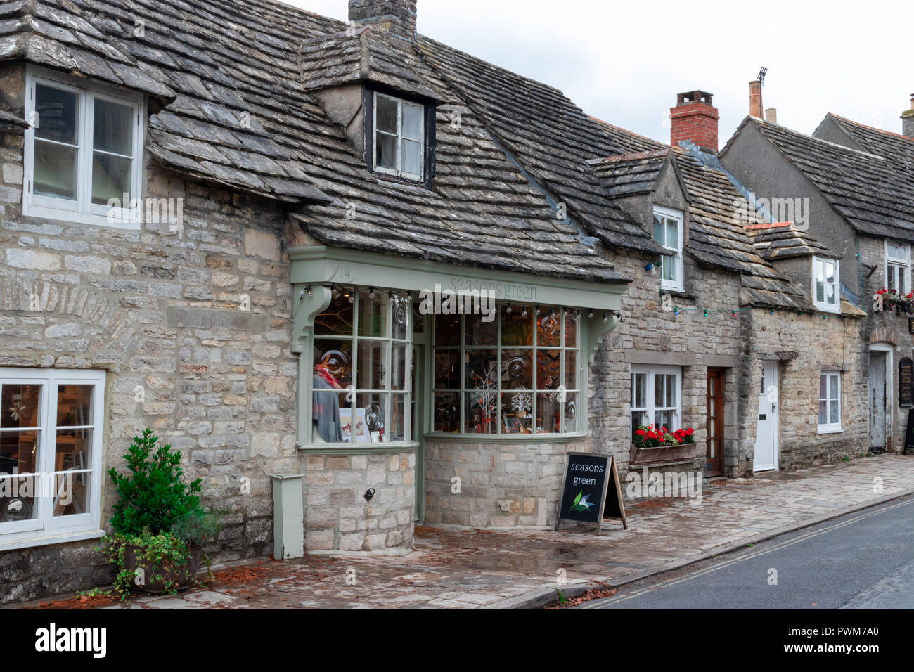 Traditionelle Steinhütten und Geschäfte in der Hauptstraße von Corfe Castle, einem historischen Dorf im Süden Englands Stockfoto