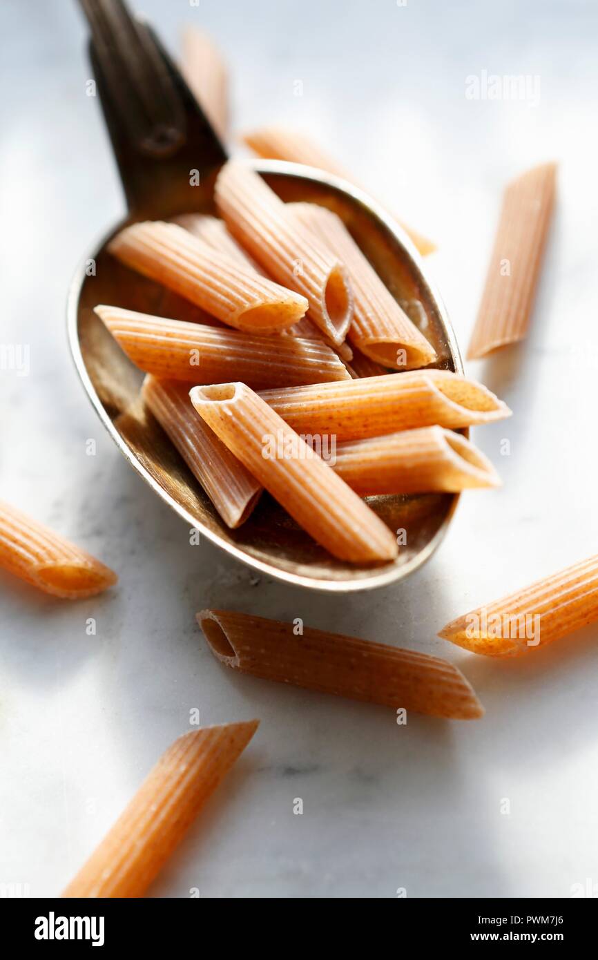 Rohe rote Penne Rigate auf einem Löffel Stockfoto