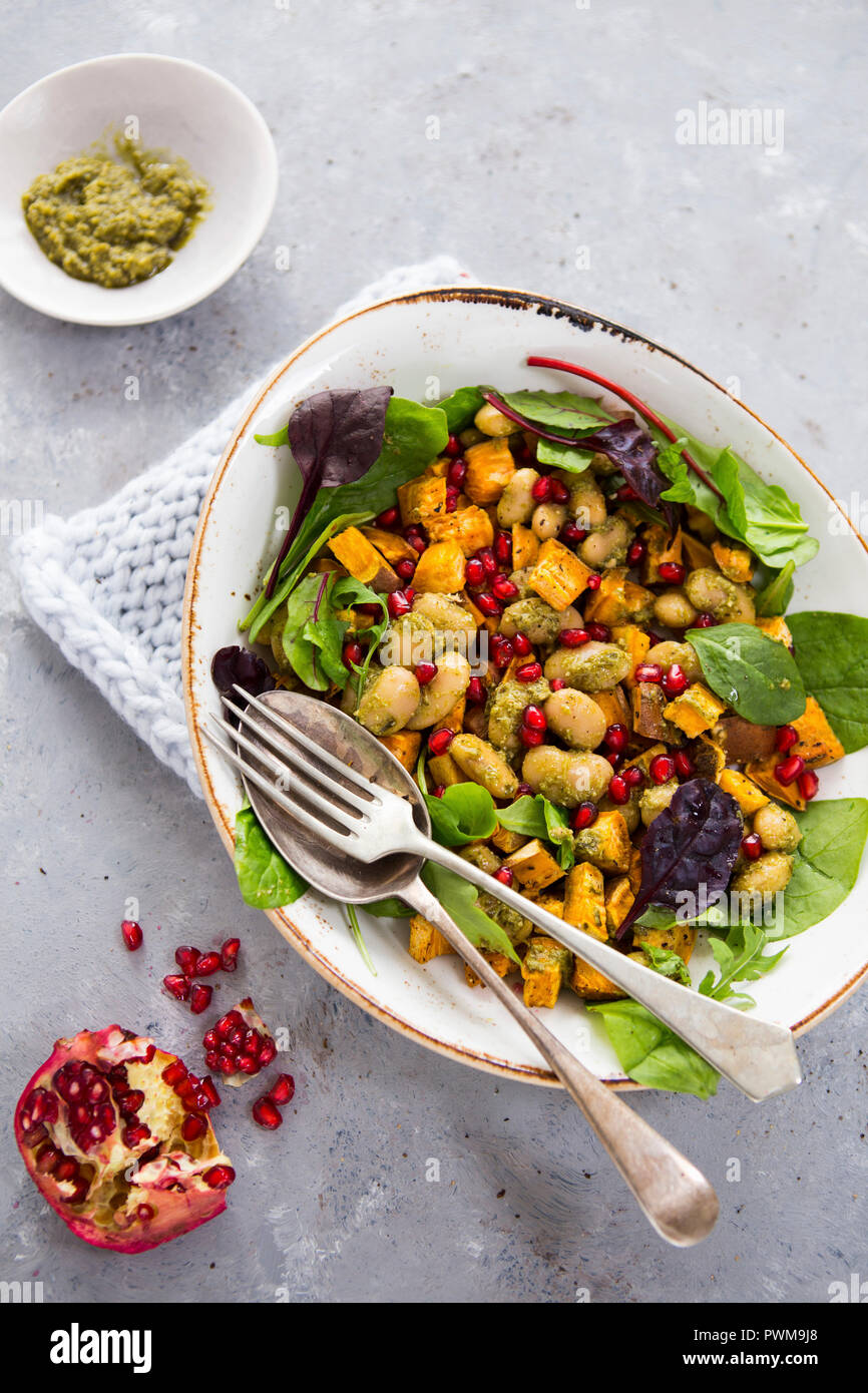 Gemüsesalat mit Butter, Bohnen, Süßkartoffeln, Granatapfel Samen und Pesto Stockfoto