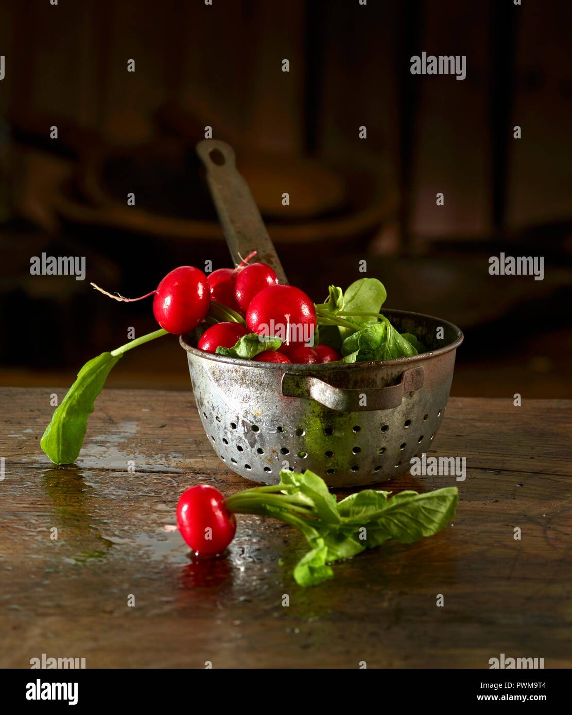 Radieschen in und vor einer alten Küche Sieb Stockfoto