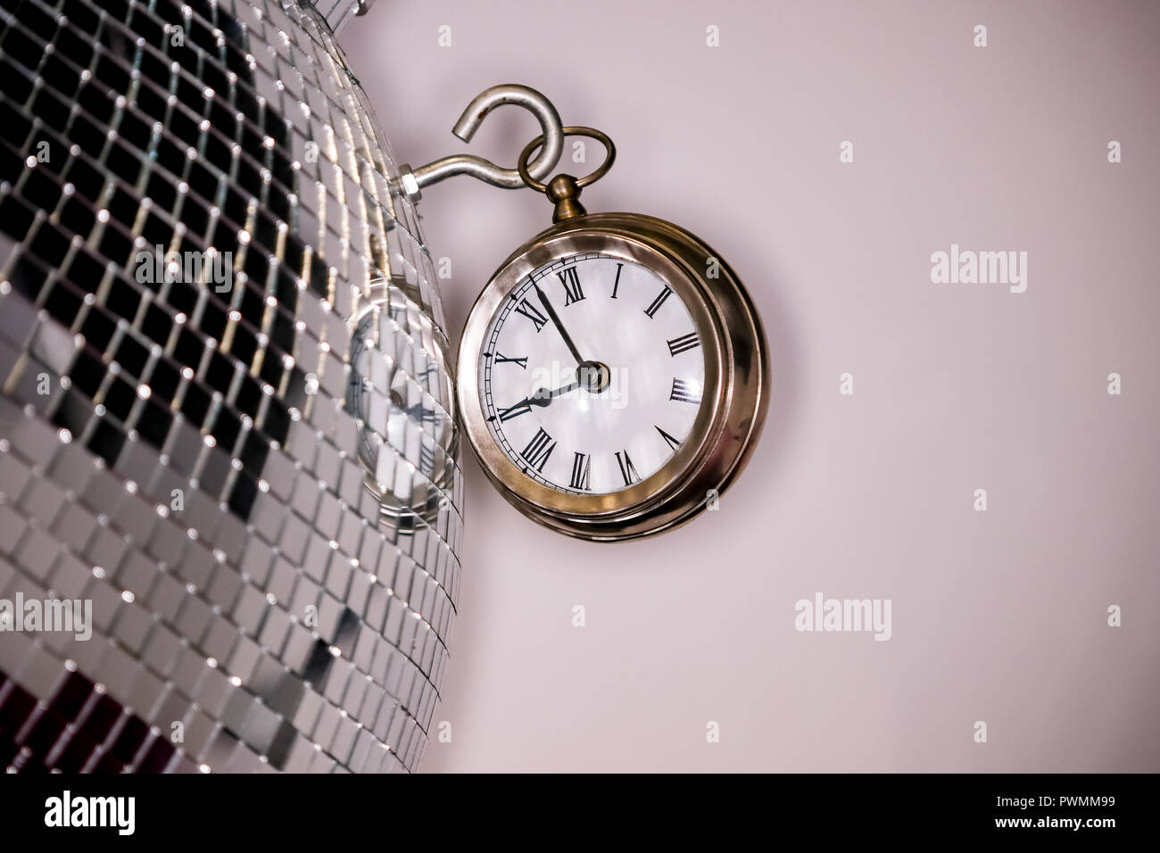 Arty Schuß eines Metall große Taschenuhr Uhr neben einem Silber Disco ball Stockfoto