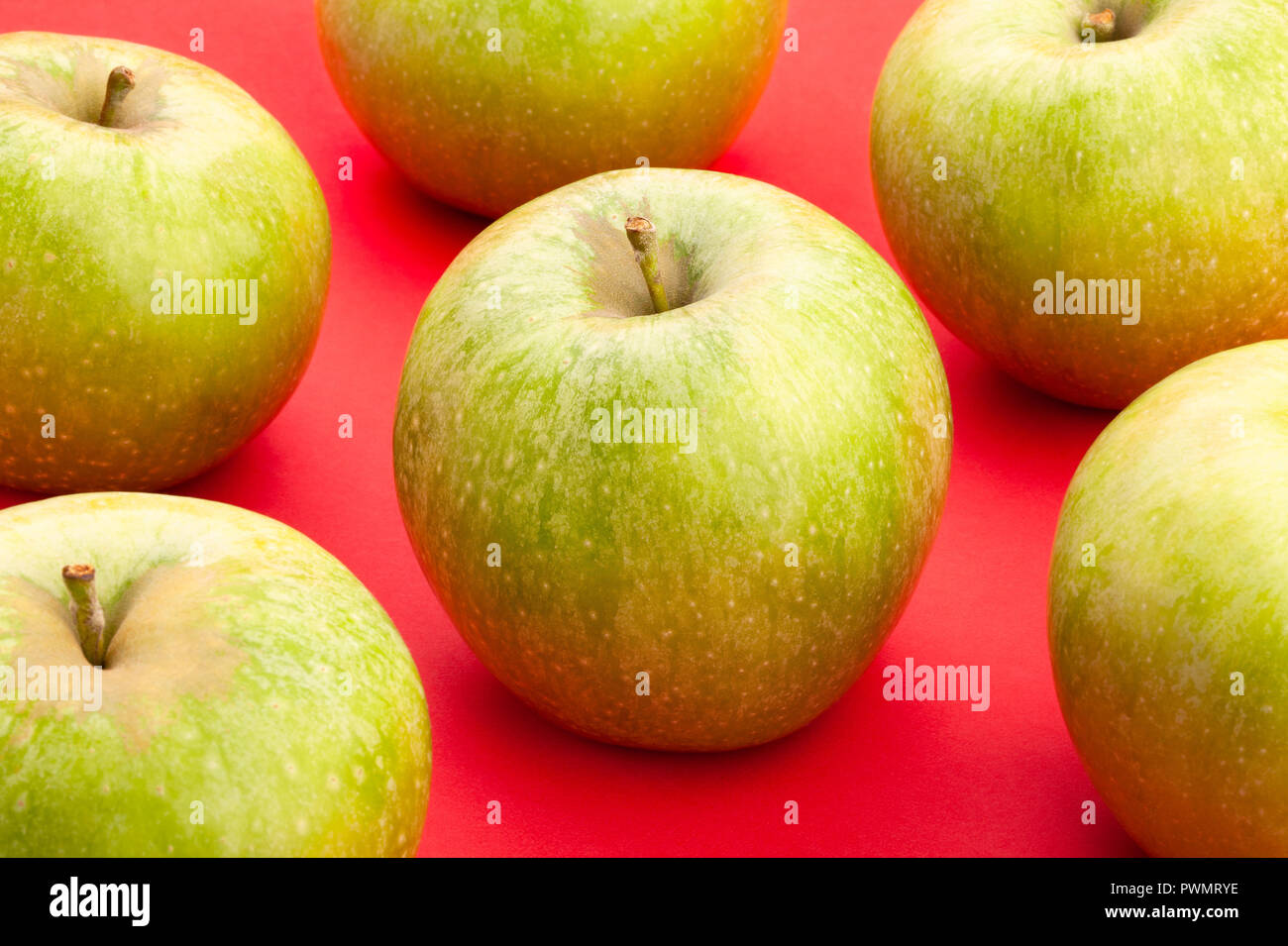 Granny Smith Äpfel auf rotem Hintergrund Stockfoto