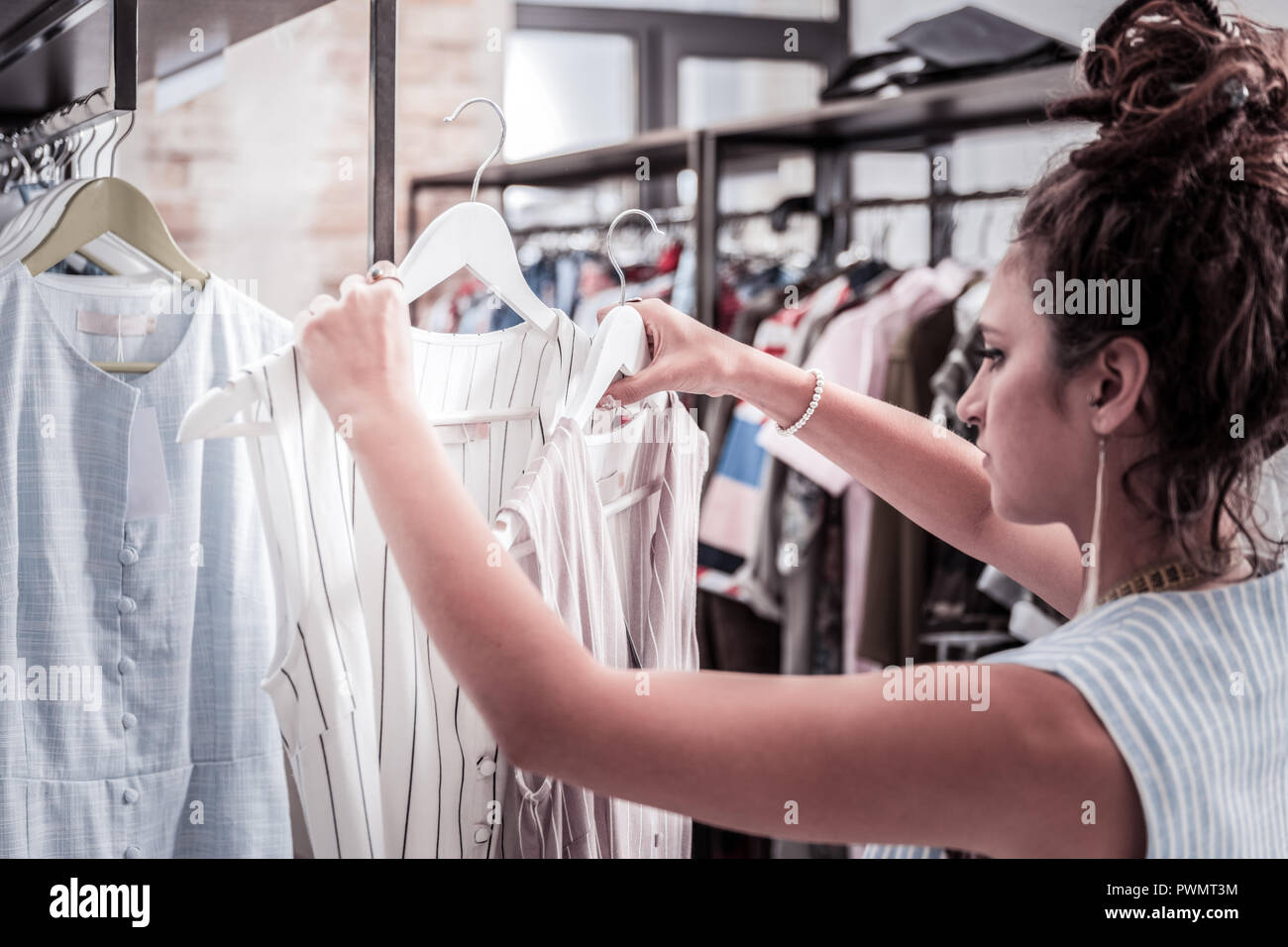 Hilfreiche Assistenten der Mode Boutique neue Sommer Kleider auf Kleiderbügeln Stockfoto