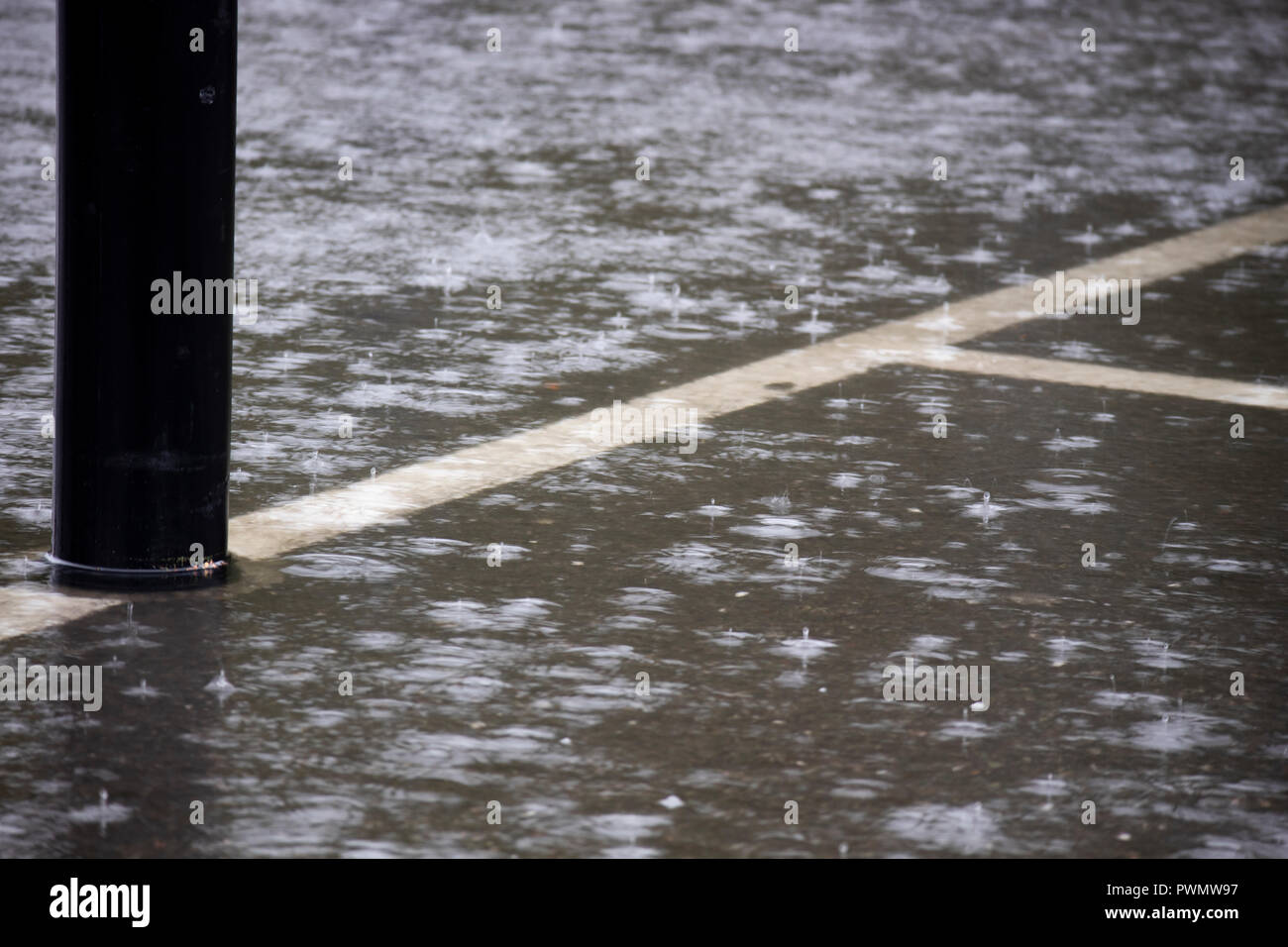 Heavy Rain mit lokalisierten Überschwemmungen in Supermarkt Parkplatz Stockfoto