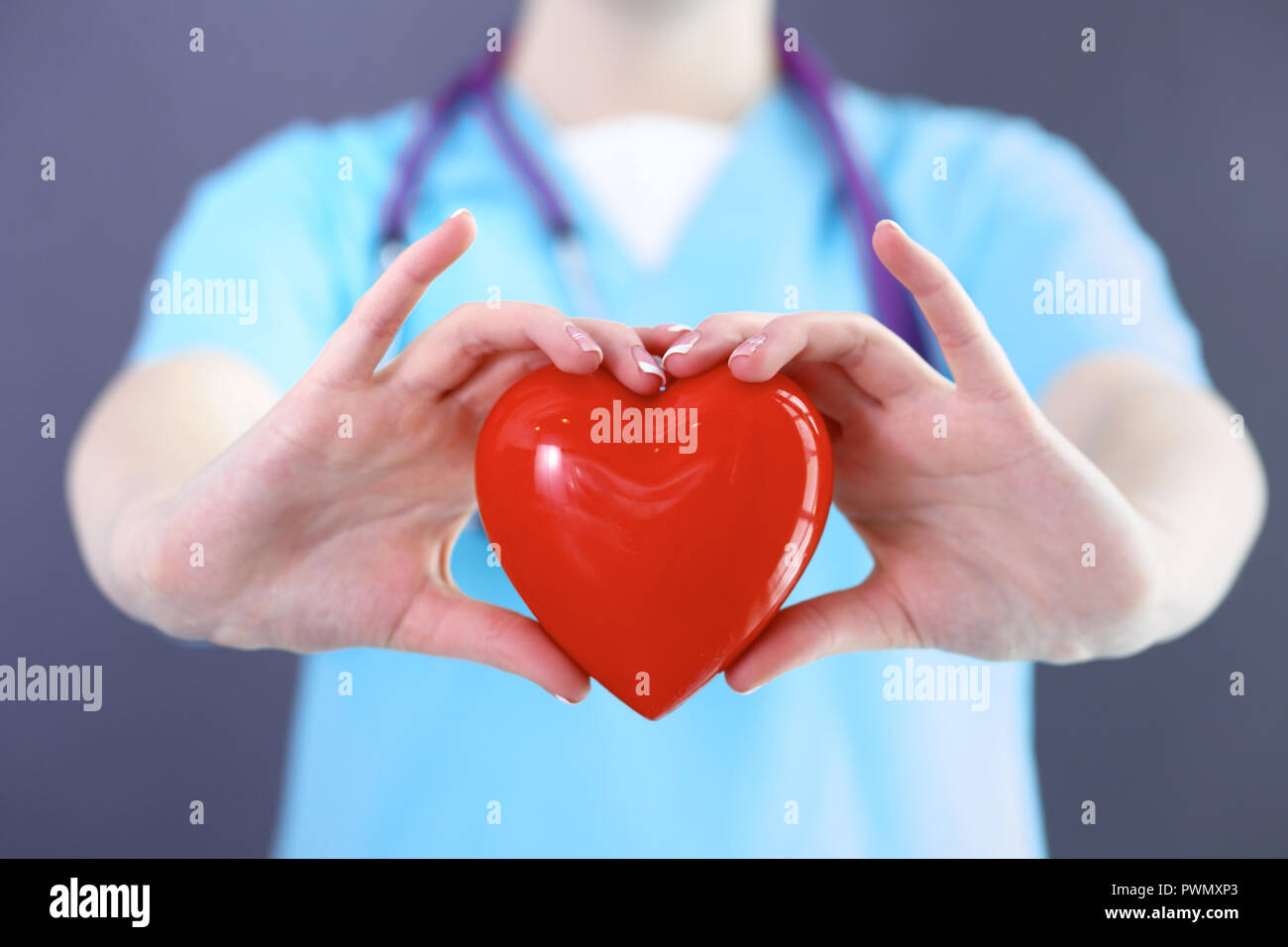 Frau Doktor mit Stethoskop holding Herz in ihre Arme. Healthcare und