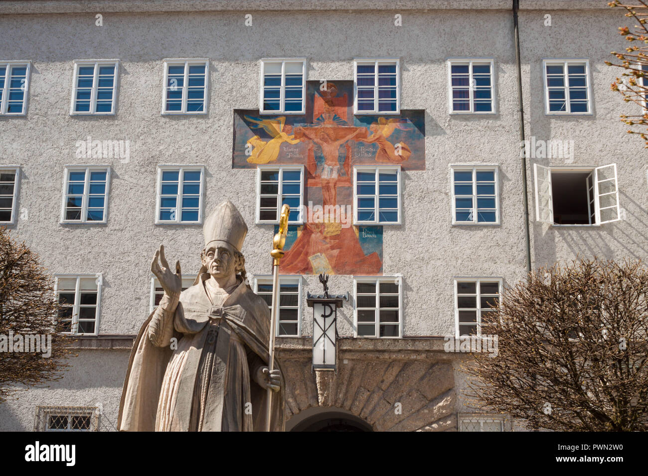 Statue des Hl. Rupert, der Salzburger Stadtpatron, und Fresko "Gnadenstuhl der Dreifaltigkeit" (Barmherzigkeit Sitz der Dreifaltigkeit) von Anton Faistauer (1926) Stockfoto