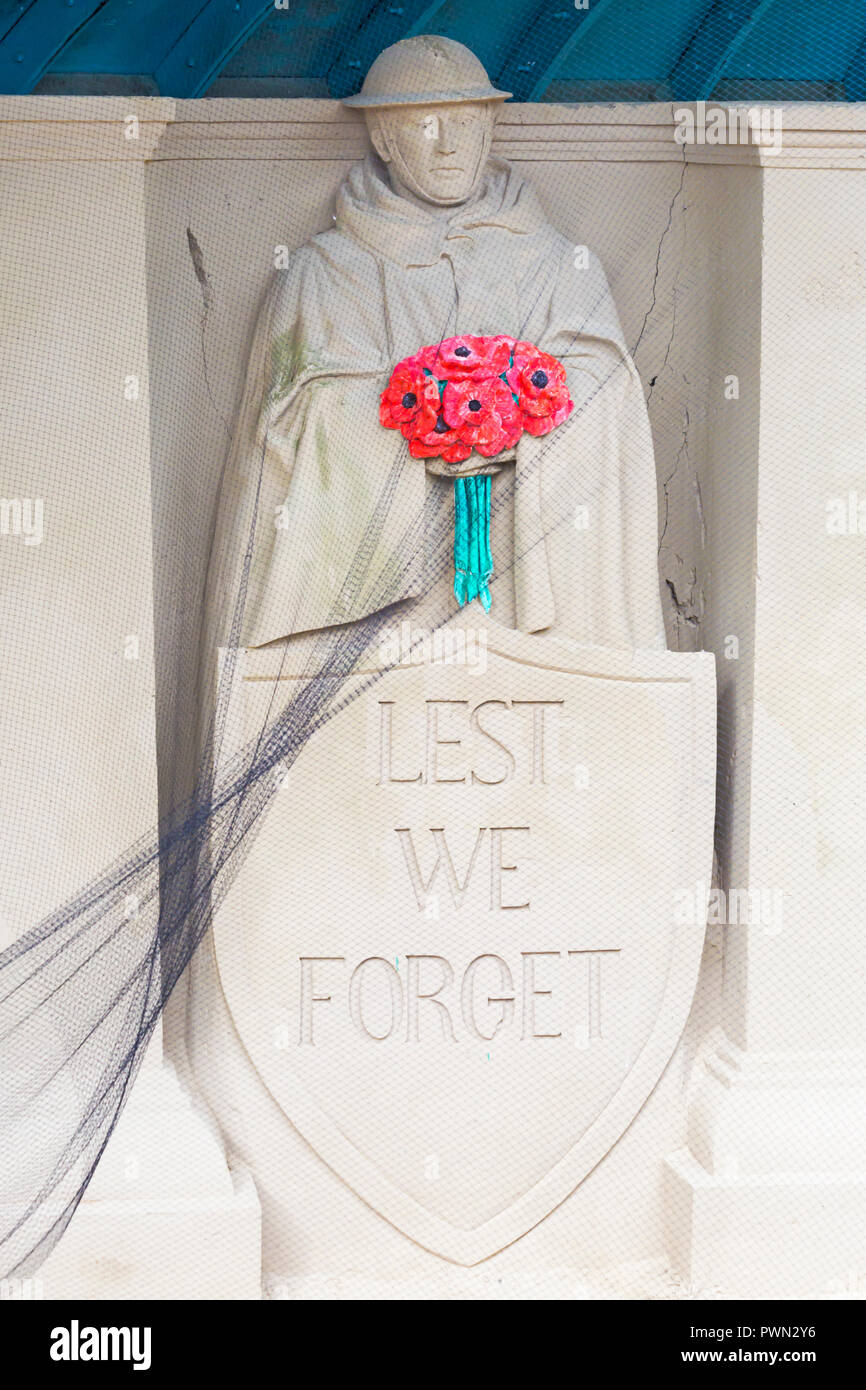 Damit wir Die Sandskulptur des Soldaten vergessen, der im Oktober Mohn am Weymouth-Strand in Dorset, Großbritannien hält Stockfoto