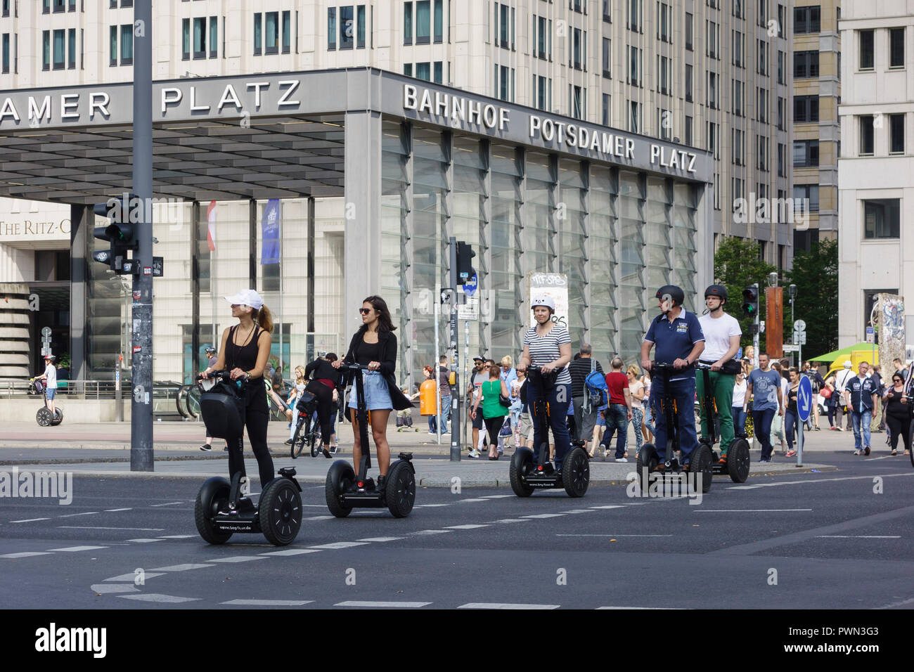 Berlin. Deutschland. Touristen, die über die Straße auf einem Segway Tour, Potsdamer Platz. Stockfoto