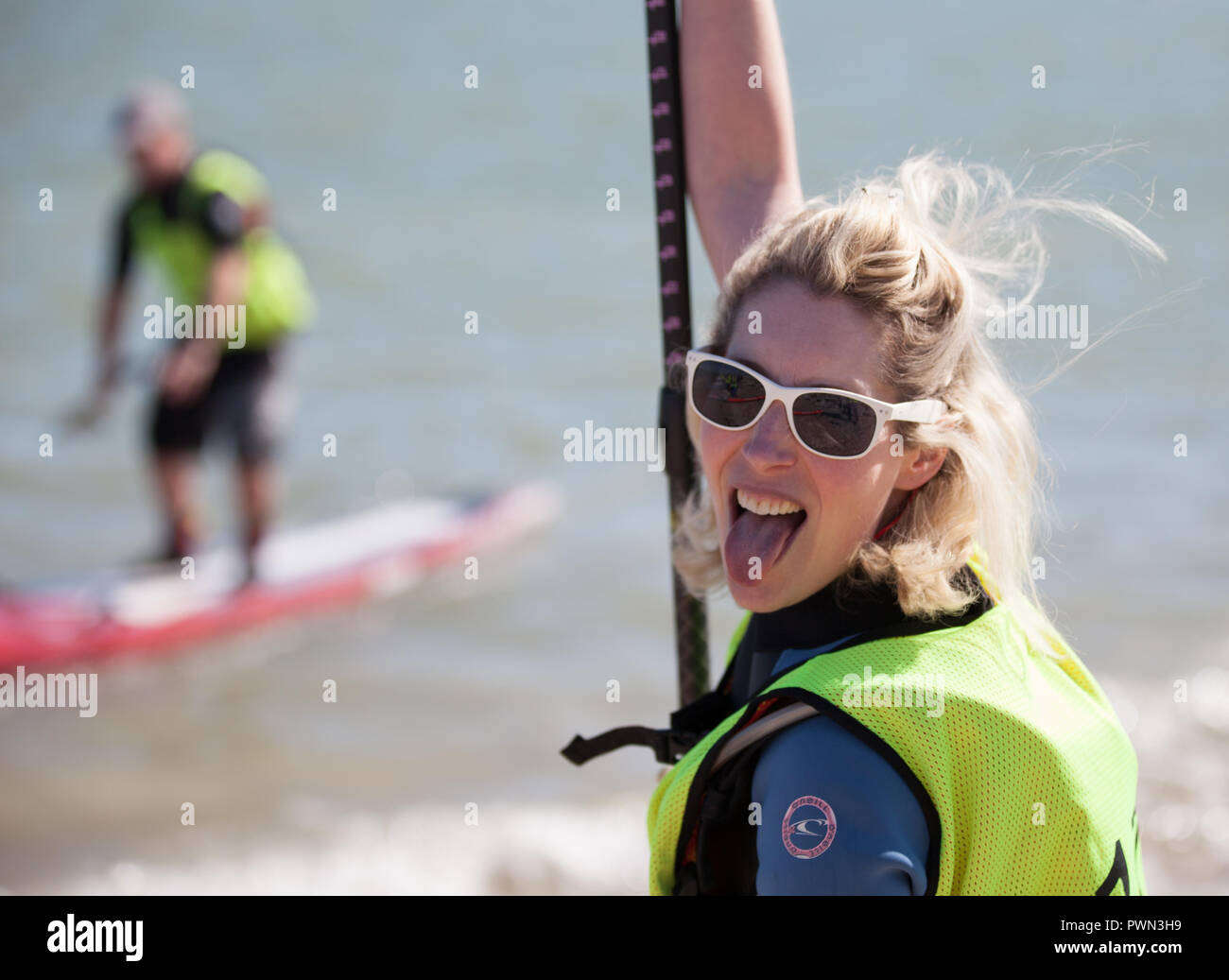 Frau über Paddle Boarding auf den Strand gehen Stockfoto