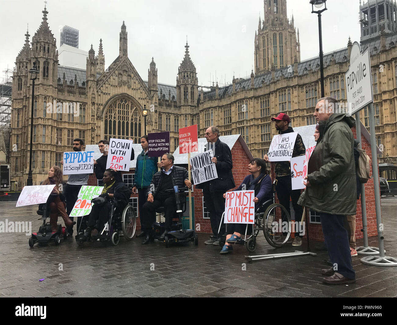 Menschen mit Multipler Sklerose (MS) und Aktivisten ketteten sich an Backsteinhäuser vor dem Houses of Parliament im Zentrum von London, um gegen die "willkürliche" 20-Meter-Entscheidung der Regierung zu protestieren, bei der nur Menschen, die nicht mehr als 20 Meter gehen können, eine "Kosteneinsparungsübung" erhalten. Stockfoto