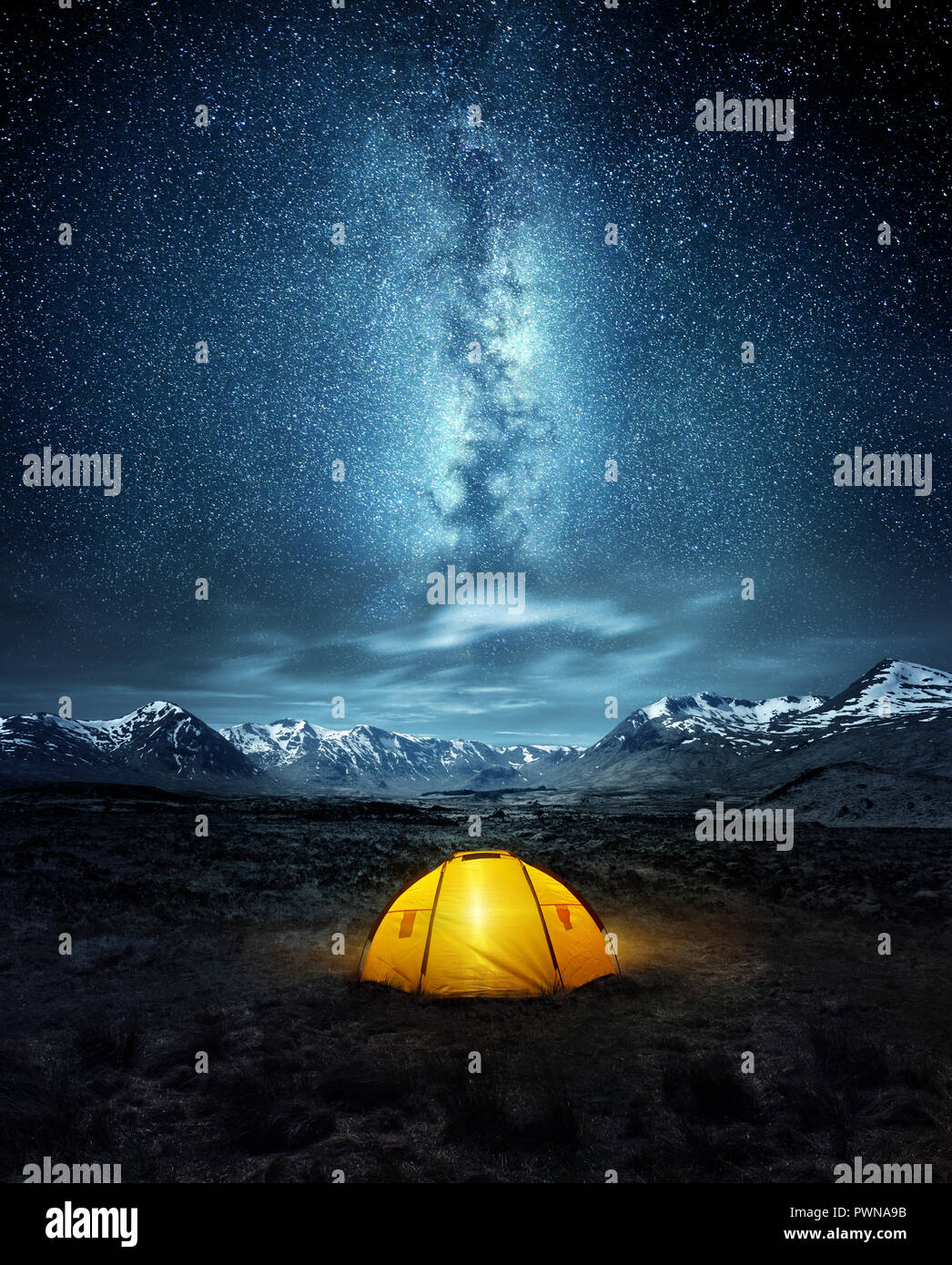 Camping in der Wildnis. Ein Zelt unter dem leuchtenden Sternenhimmel Sterne der Milchstraße mit schneebedeckten Bergen im Hintergrund. Natur Landschaft Stockfoto