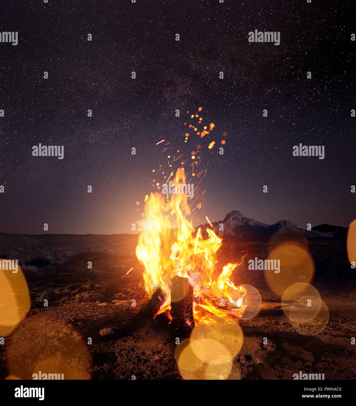 Beobachten der Sterne um einen leuchtenden warmen Lagerfeuer in der Nacht. Foto Composite. Stockfoto
