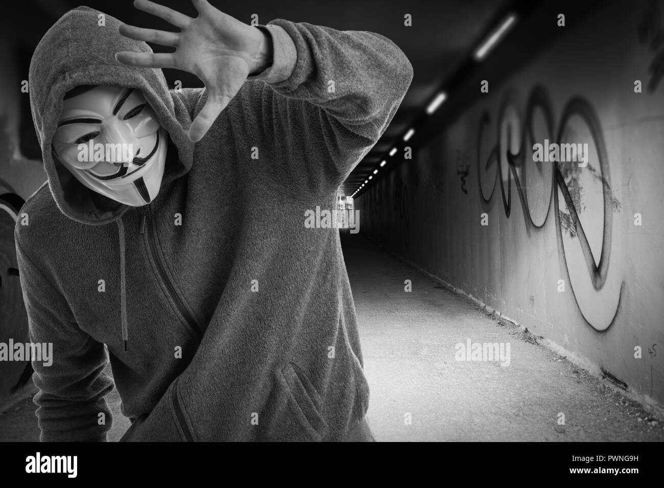 Mann, der eine Guy Fawkes Maske am Eingang zu einem tummel, anonym. Stockfoto