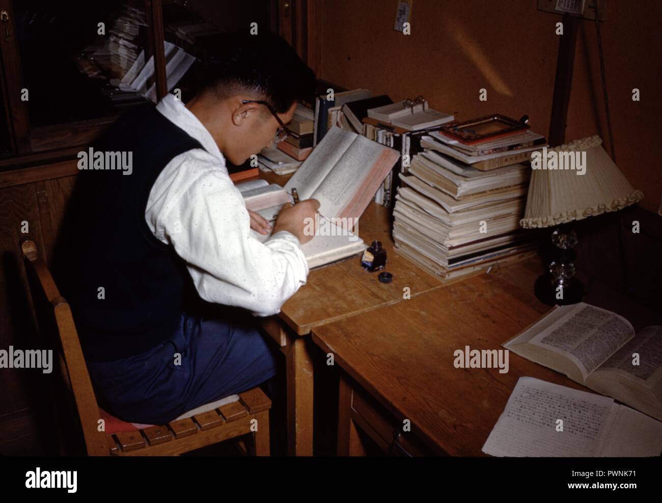 Asiatischer mann Kopien eines Buchs mit Tinte, in seiner Studie, 1965. () Stockfoto