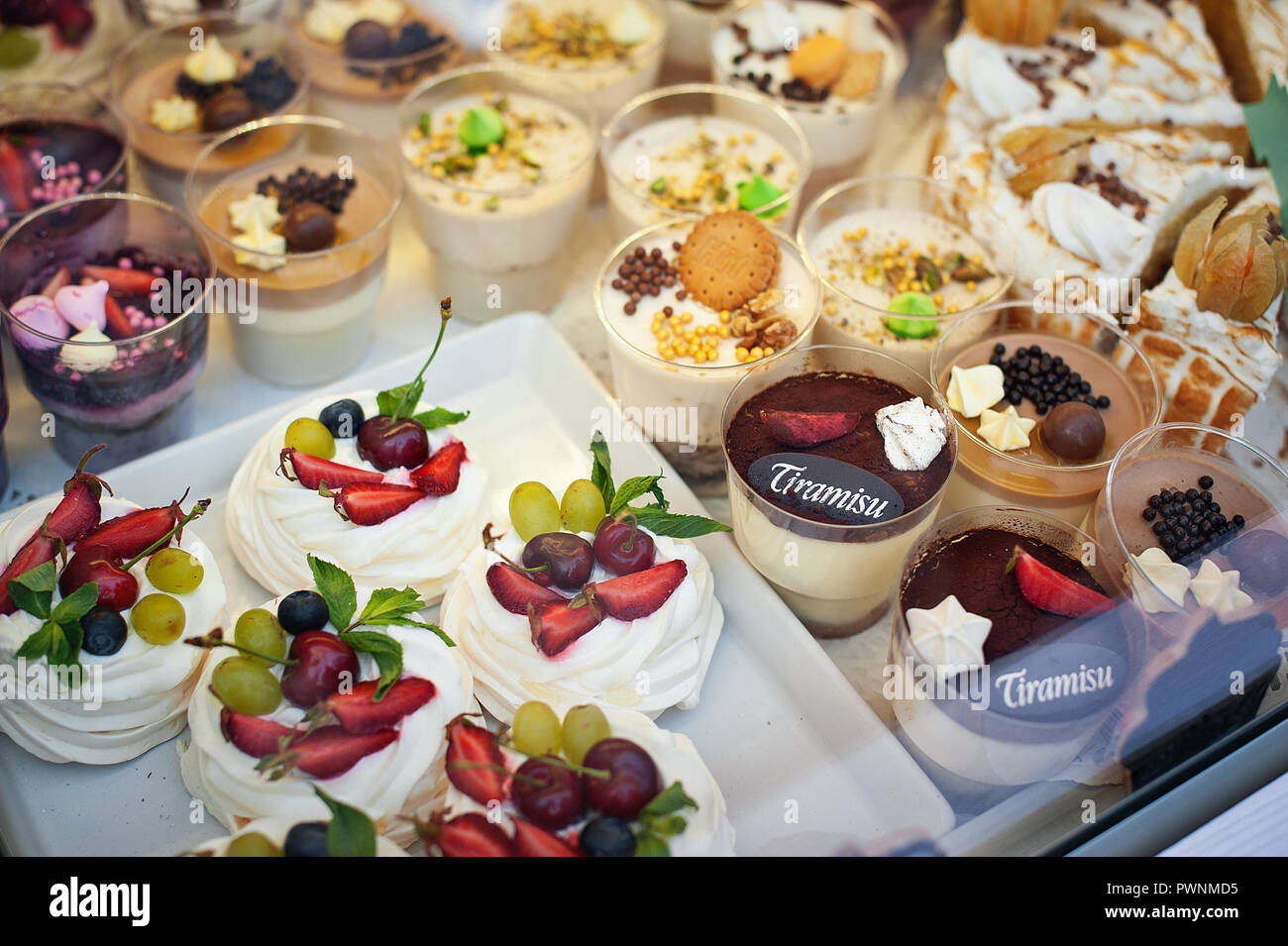 Vitrine mit vielen verschiedenen Desserts. Pavlova, Tiramisu, Kuchen und Mousses Stockfoto
