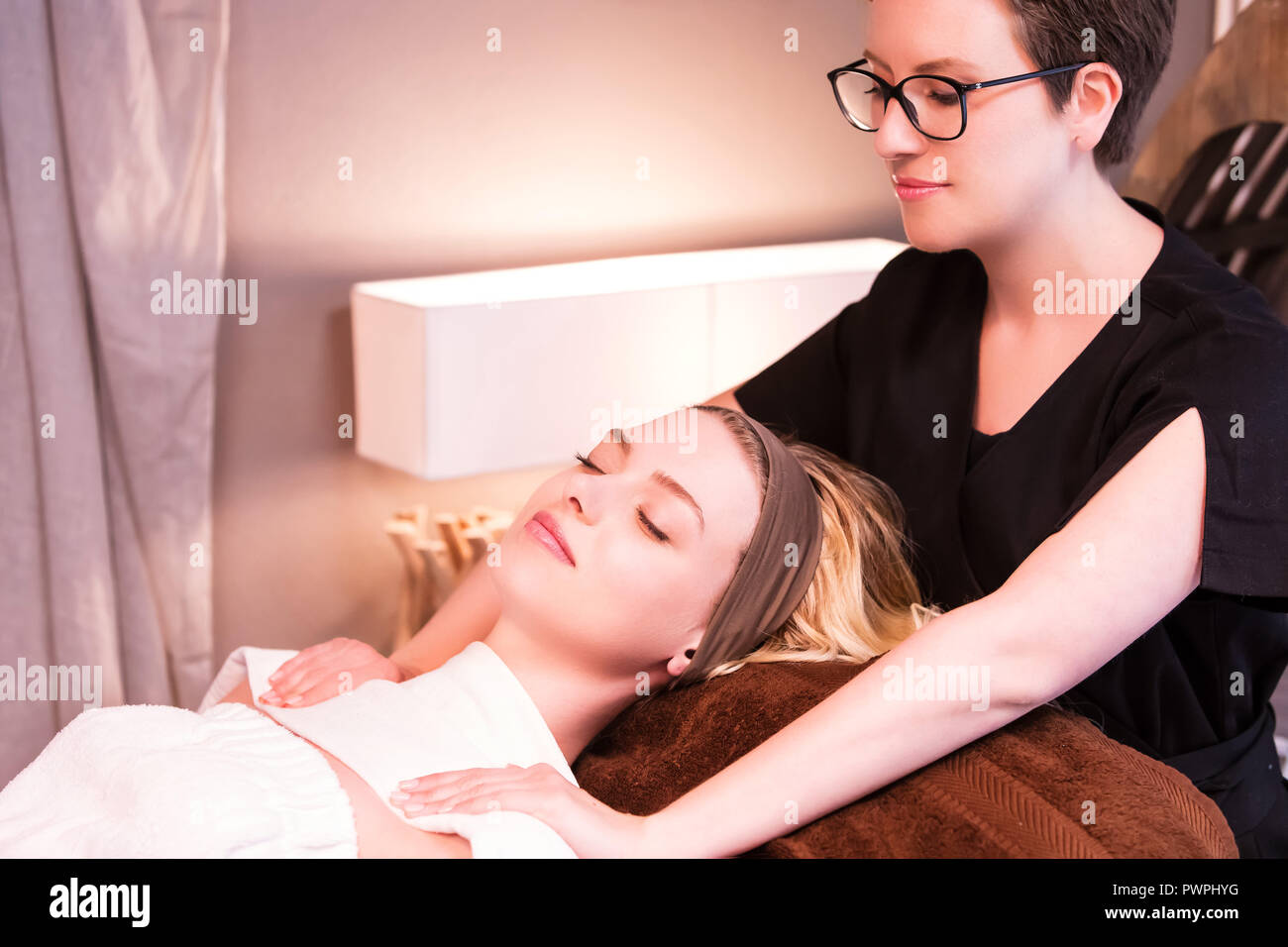 Masseurin massiert die Schultern einer jungen Frau Stockfoto Masseurin massiert die Schultern einer jungen Frau Stockfoto